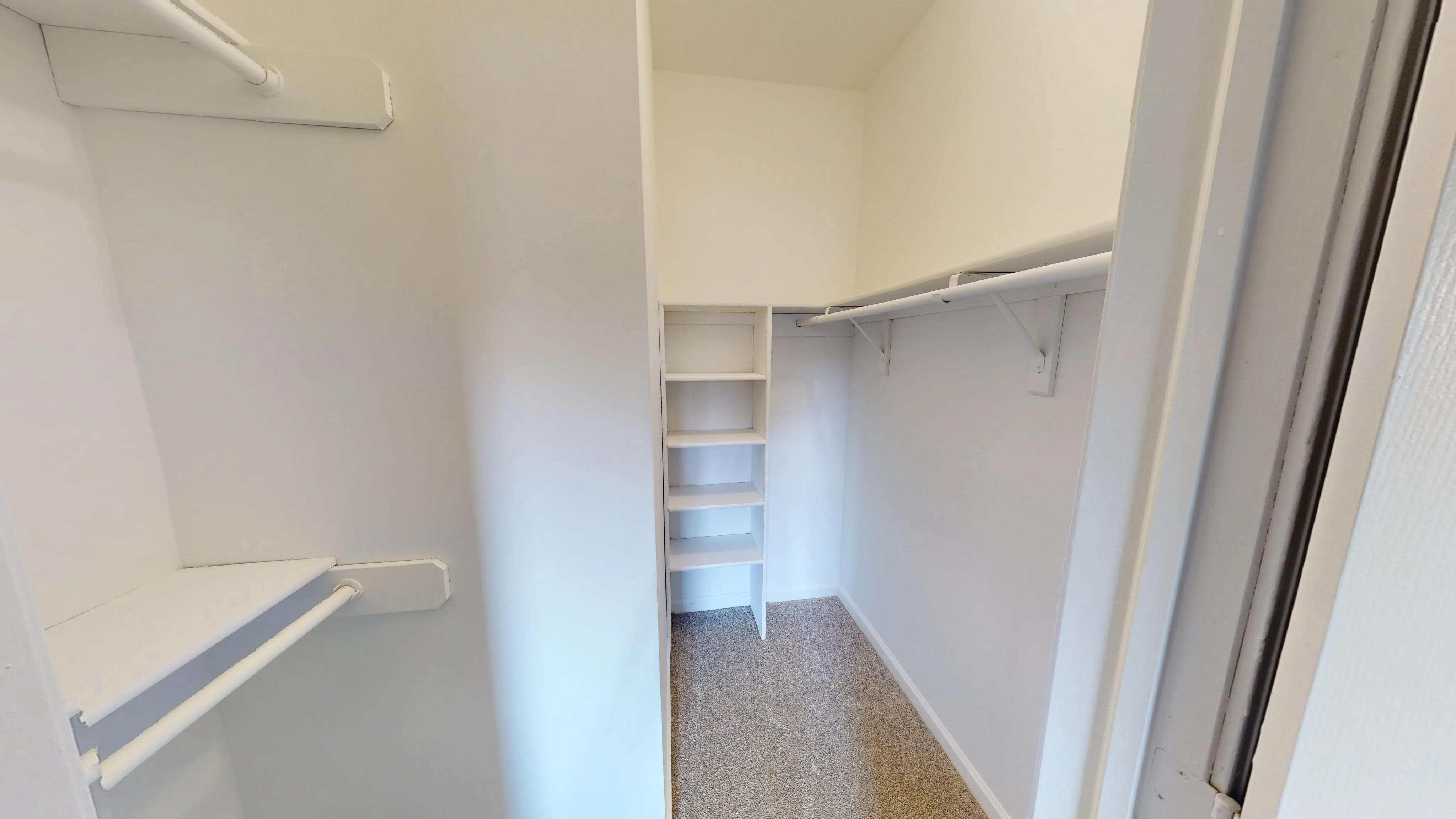 Spacious walk-in closet with ample shelving and hanging space, perfect for organized storage and a clutter-free lifestyle.