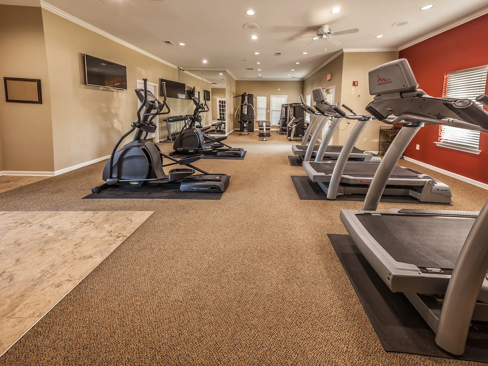 River Ridge Modern fitness center with state-of-the-art treadmills and ellipticals in a spacious, well-lit room.