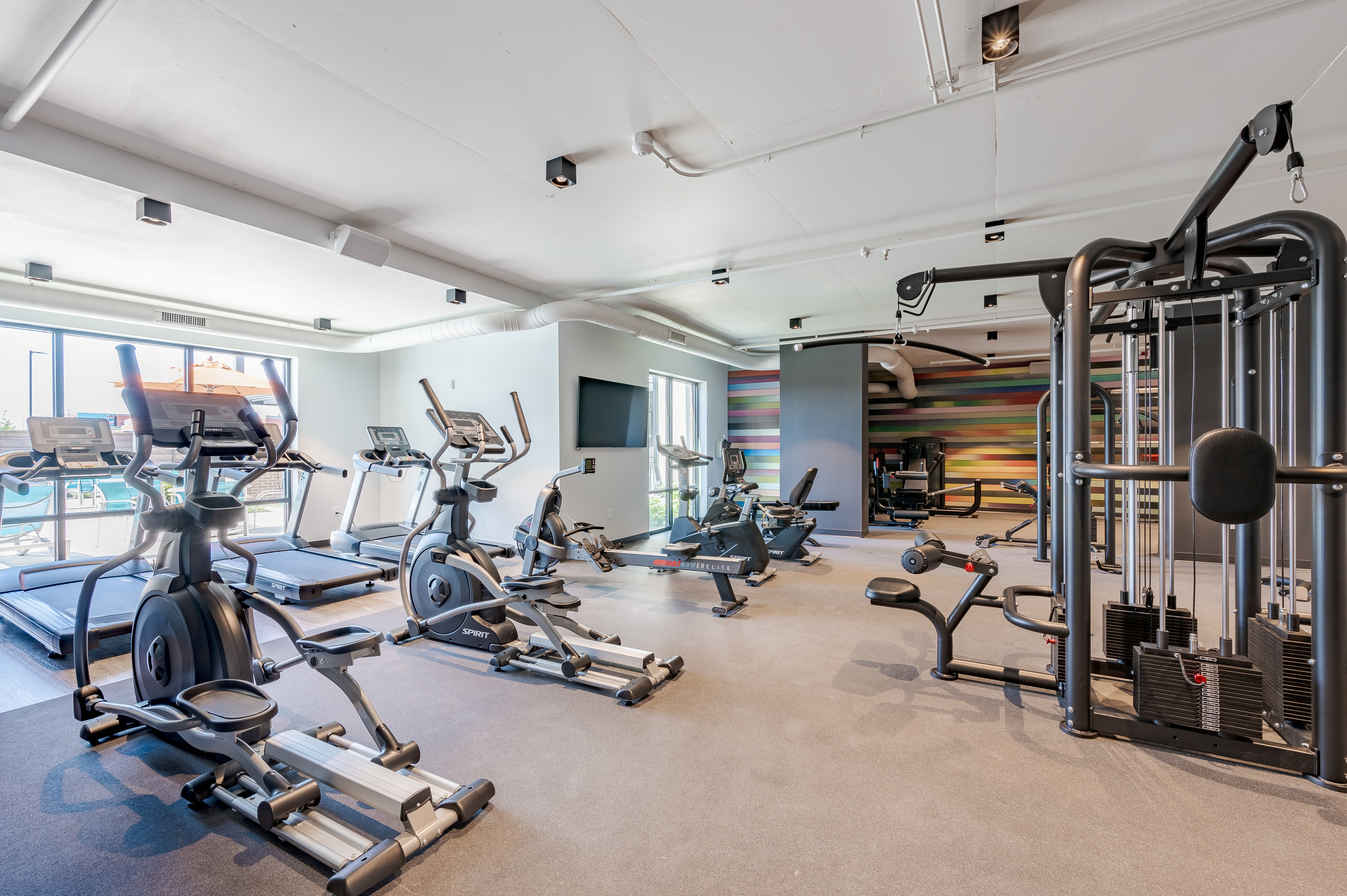 Spacious and well-equipped fitness center featuring modern cardio machines and vibrant decor.