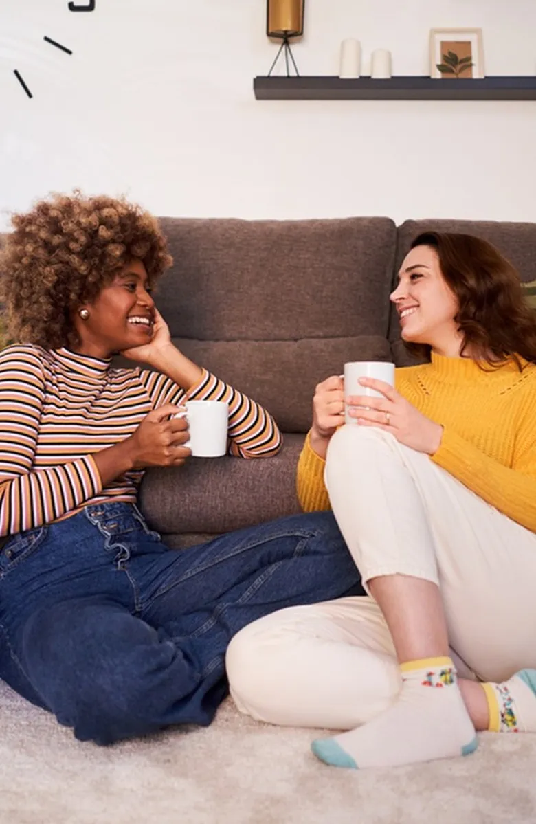 2 People laughing while sitting on the floor in living area