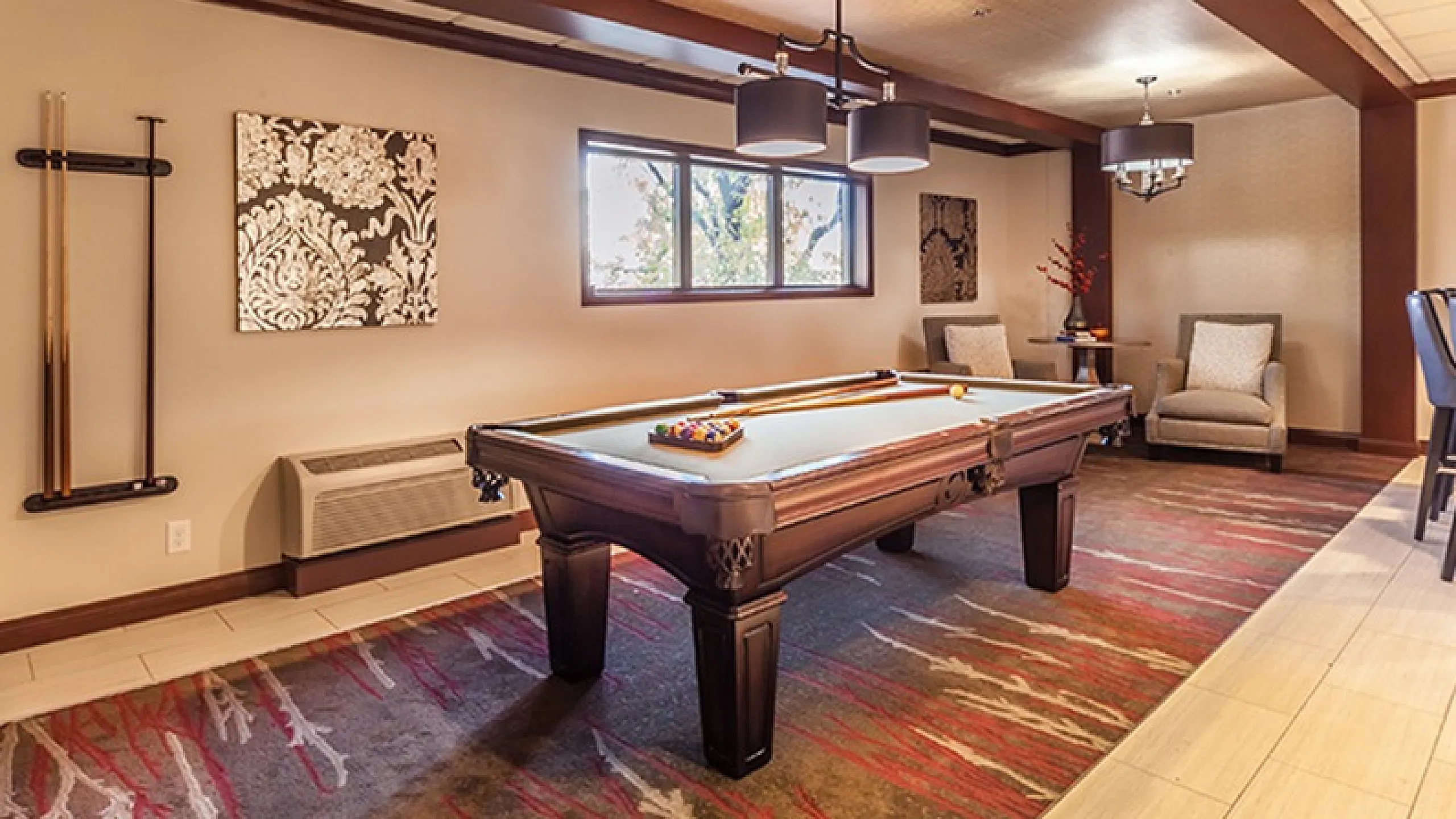 Elegant entertainment room featuring a classic billiards table, stylish decor, and comfortable seating, perfect for leisure and social gatherings.