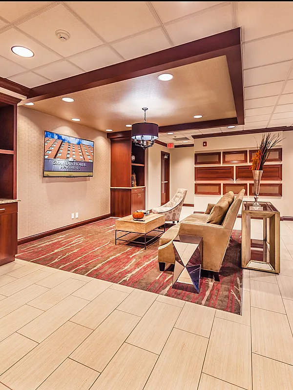 Elegant lobby interior featuring modern decor with plush seating, stylish shelving units, and ambient lighting.