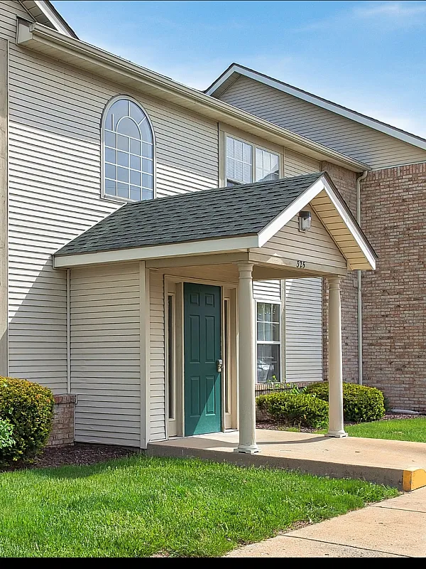 Charming apartment exterior with attractive landscaping, modern siding, and a welcoming entrance, perfect for comfortable living.
