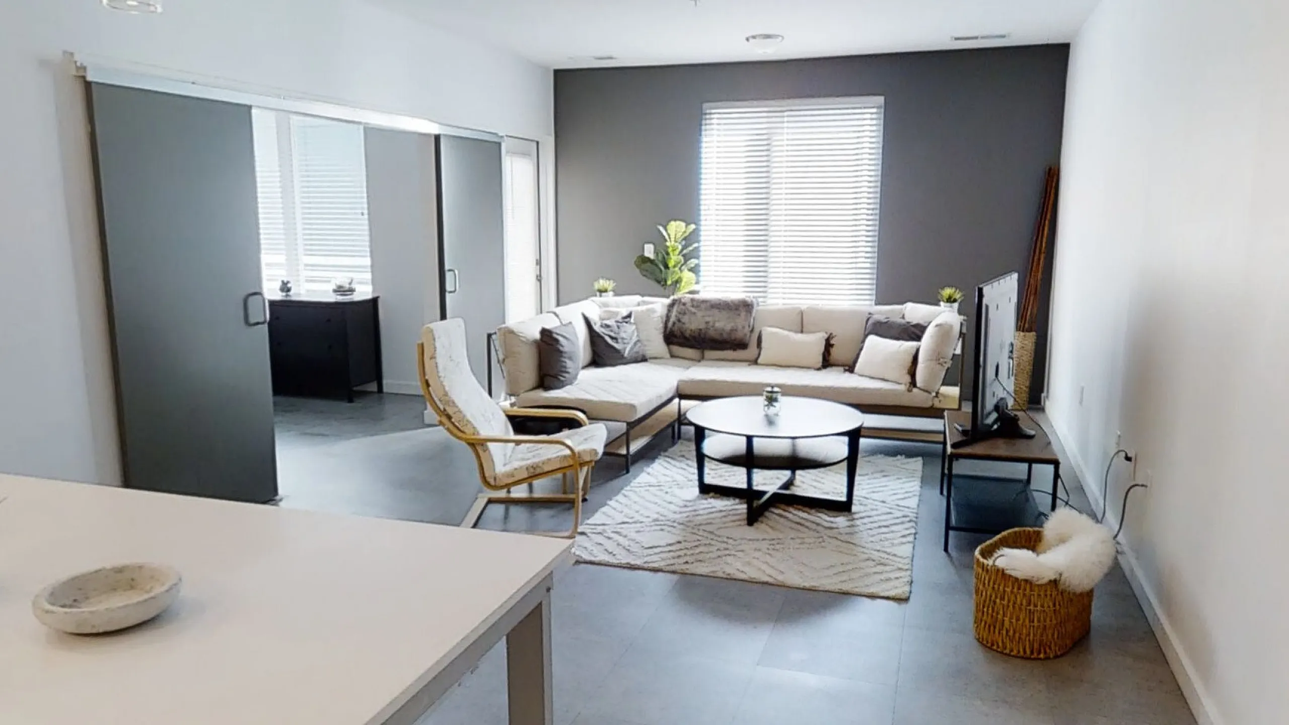 Modern apartment living room with cozy sectional sofa, sleek coffee table, and warm natural light.