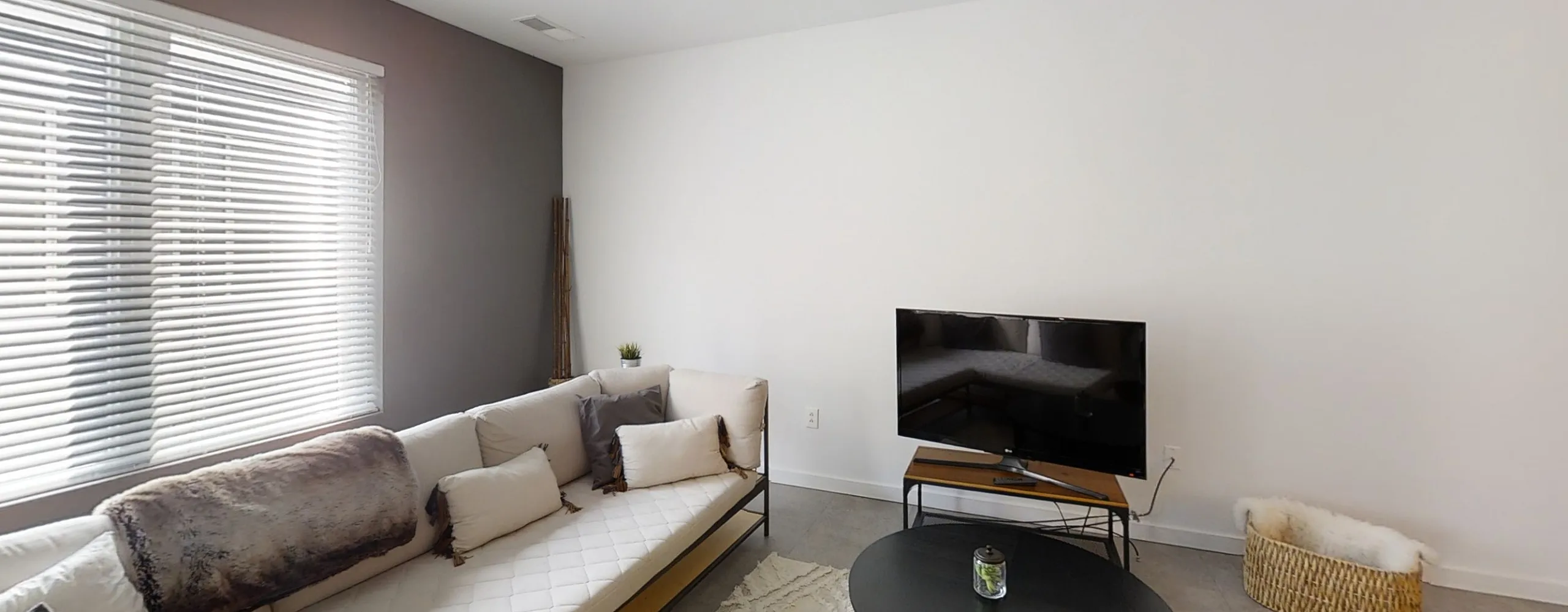Modern living room with cozy white sofa, stylish black coffee table, and large windows for natural light.