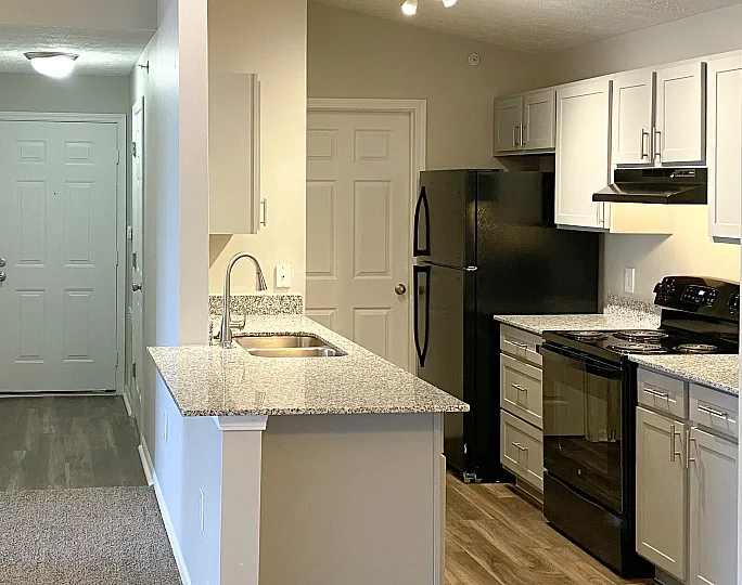 Modern kitchen with granite counterti=ops and light grey cabinets at Eagle Chase Apartments