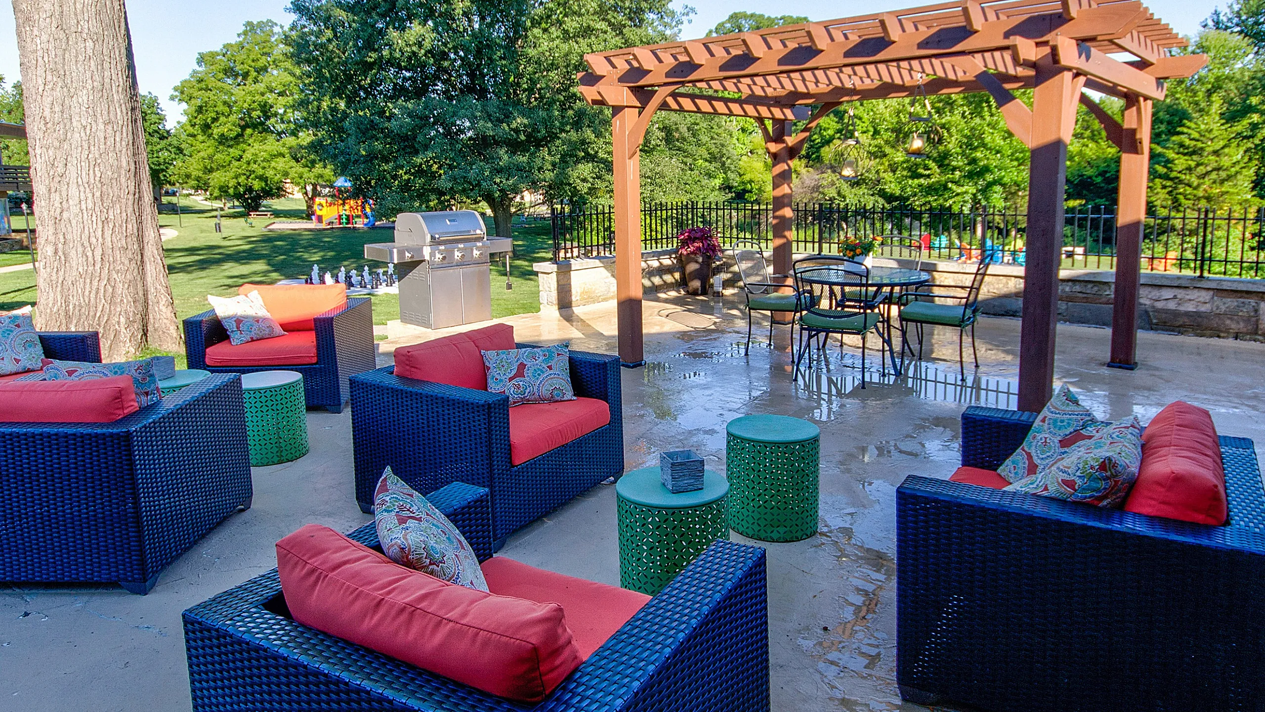 Inviting outdoor patio with vibrant seating and stylish pergola set in lush greenery.