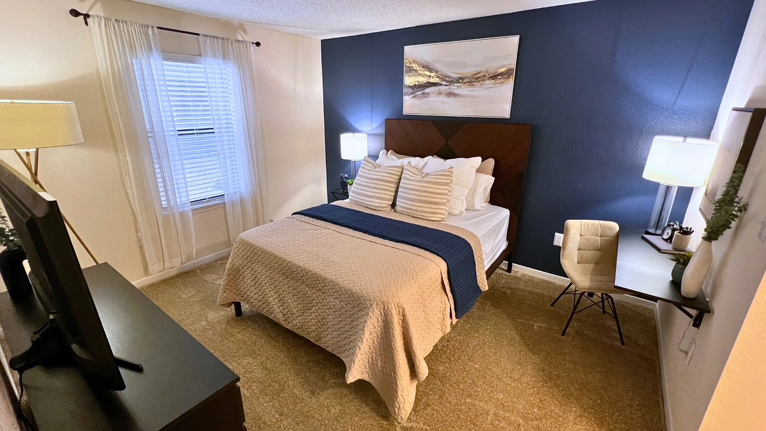 Inviting bedroom with a cozy bed, elegant decor, and warm lighting, perfect for relaxation.