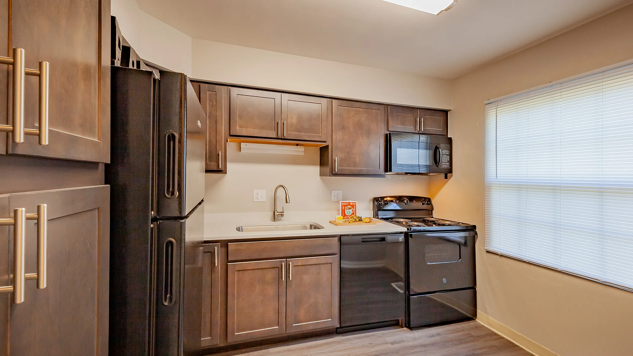 Charming kitchen with dark wood cabinetry, modern appliances, and ample natural light for a cozy culinary experience.