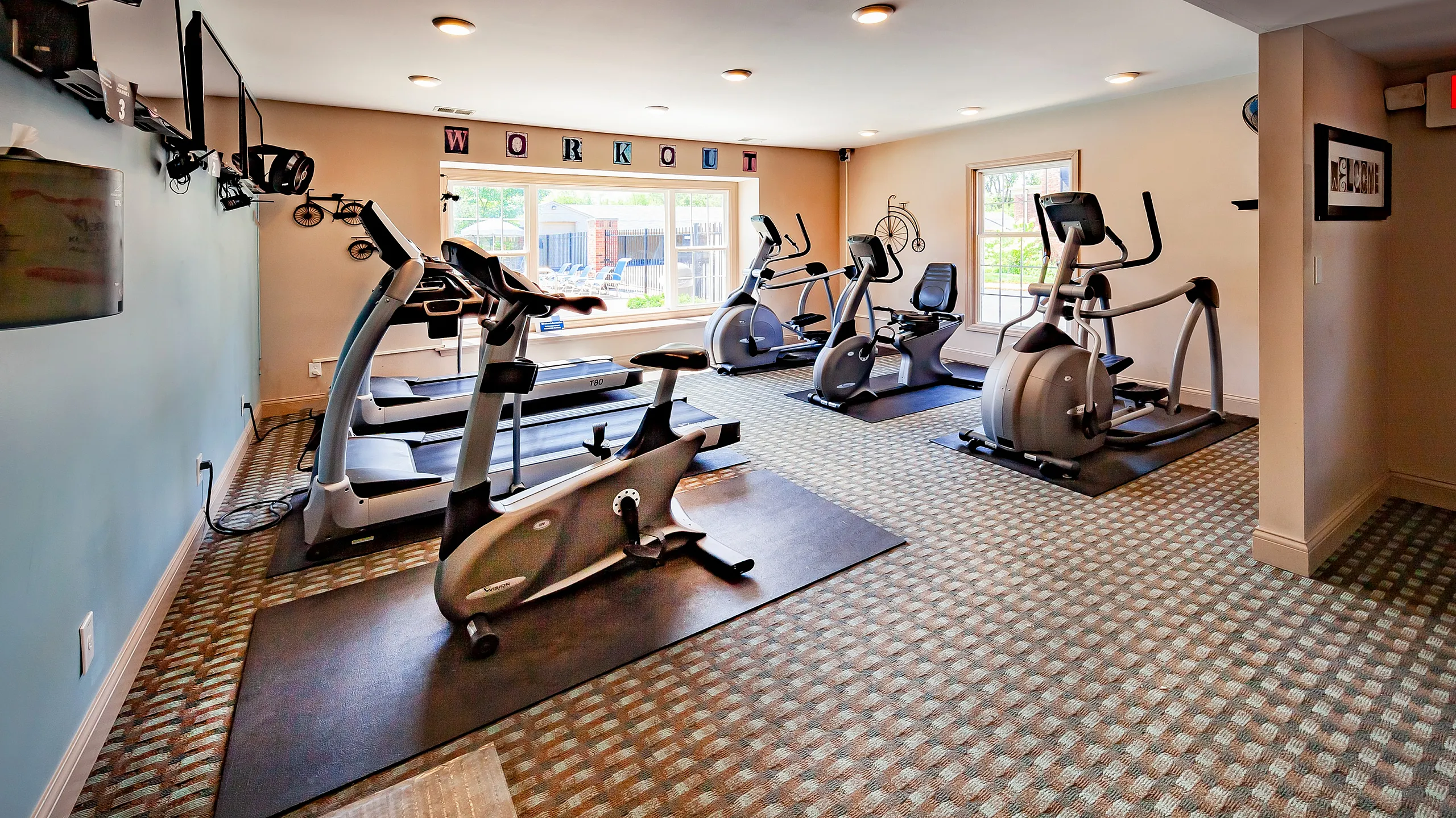 Inviting fitness room featuring modern exercise machines, vibrant lighting, and a motivating atmosphere.