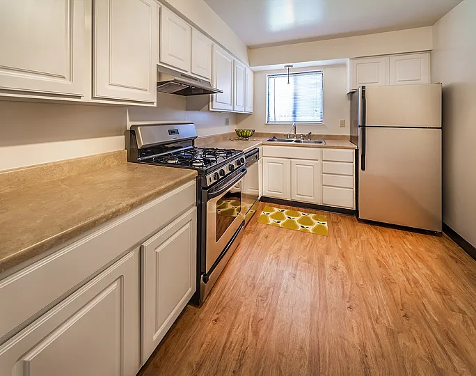 Charming kitchen with modern appliances, warm wood flooring, and ample counter space, perfect for culinary exploration and gatherings.