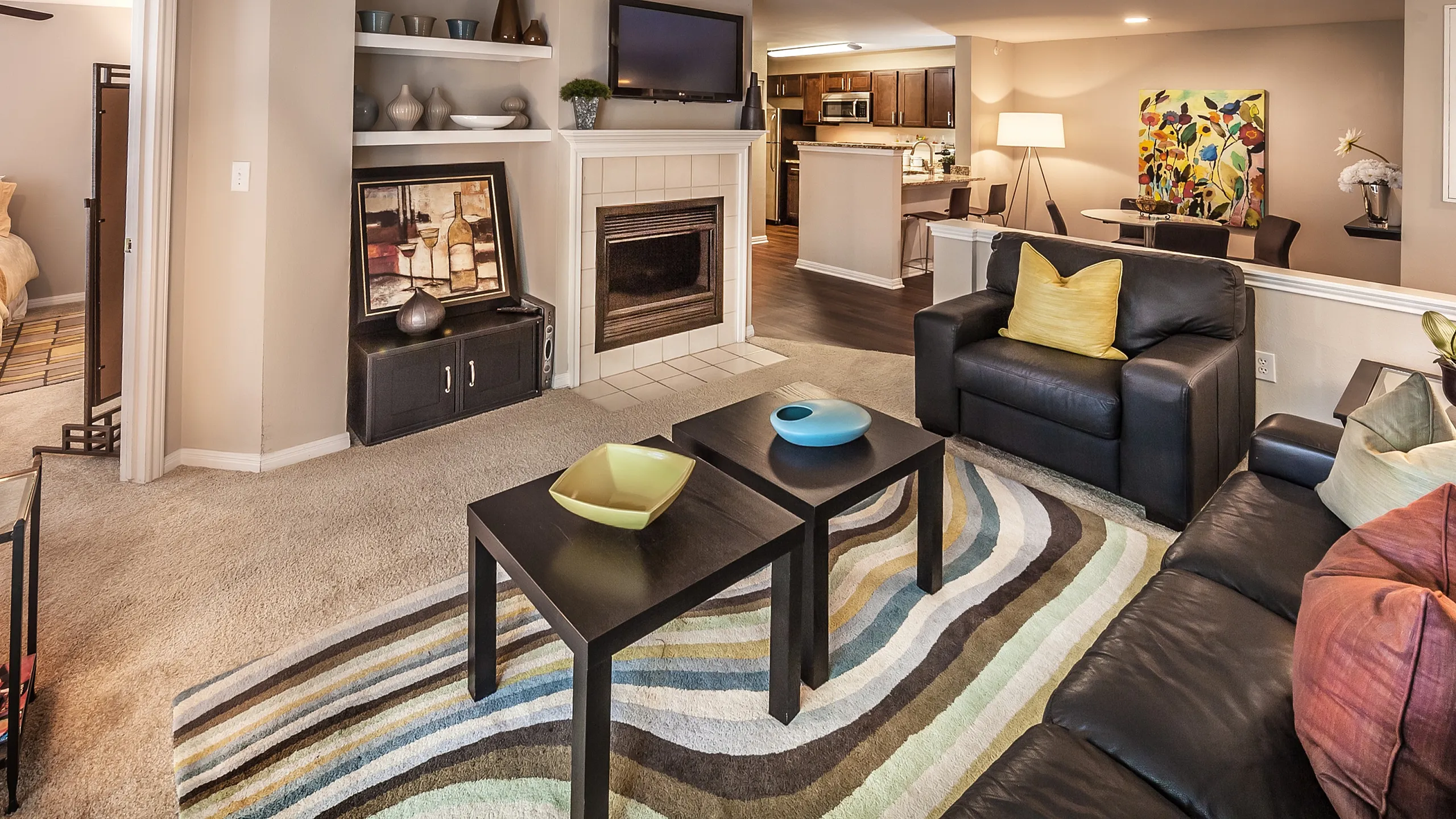 Contemporary apartment living room with cozy seating, vibrant decor, and an open layout adjacent to a modern kitchen.