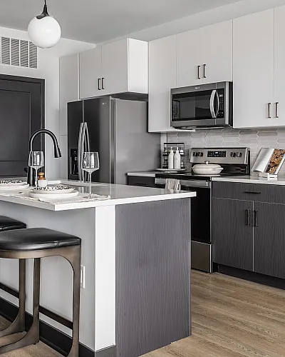 Sleek modern kitchen with an island breakfast bar, polished countertops, and stylish pendant lighting.