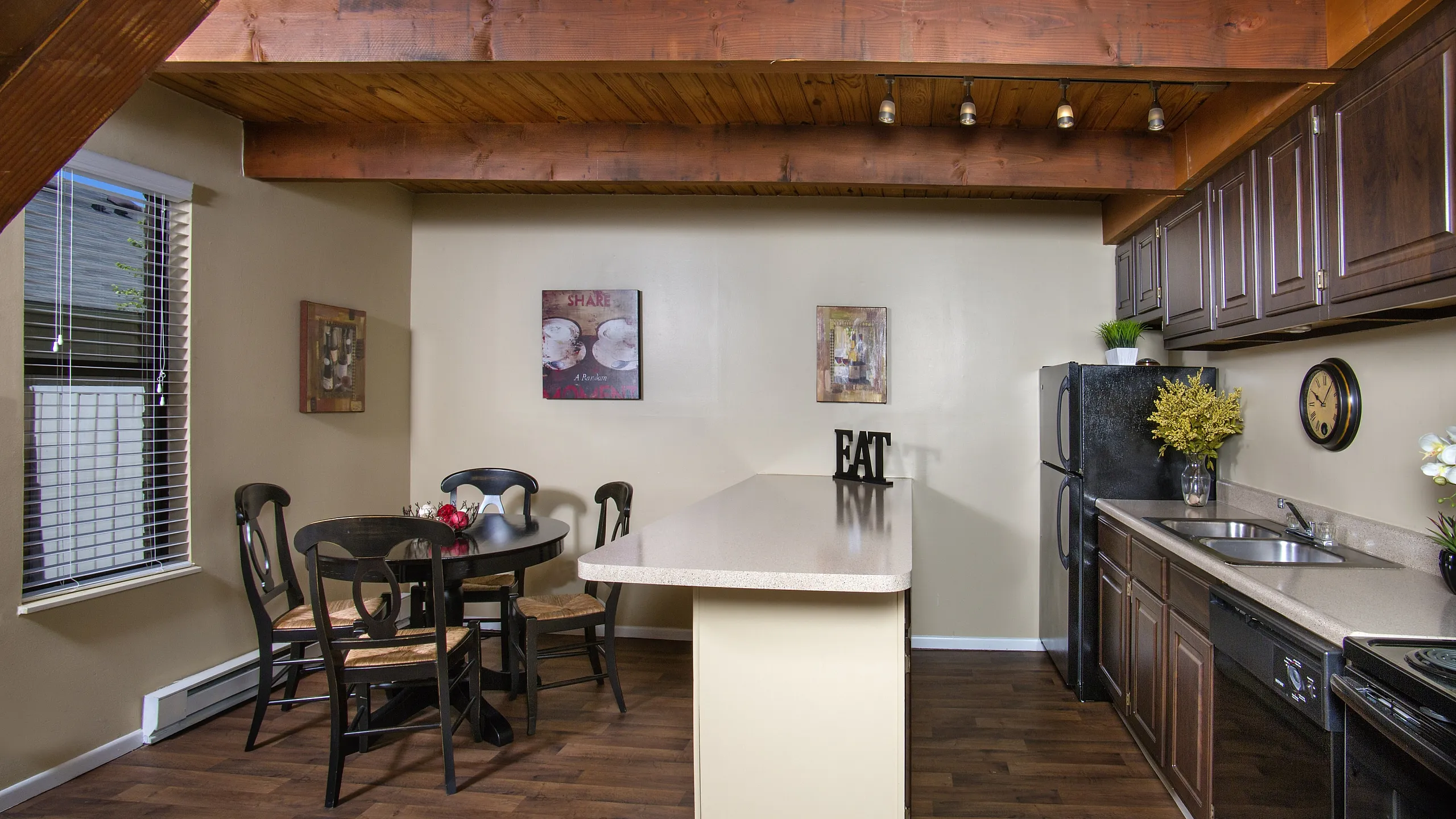 Charming kitchen with rustic wooden beams, cozy dining area, and modern appliances, perfect for entertaining.