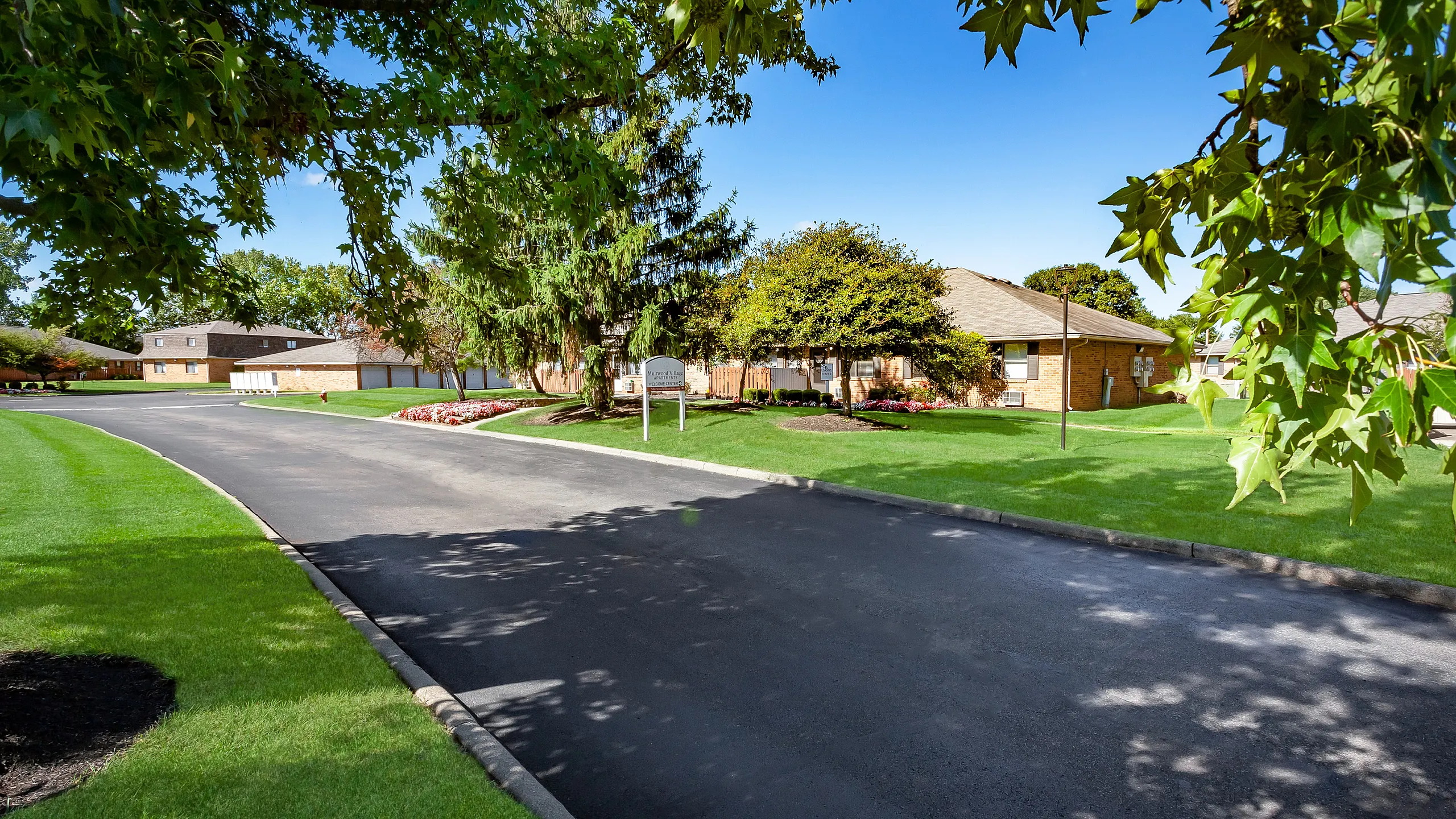 Inviting suburban landscape with lush greenery and charming brick homes, perfect for tranquil living.