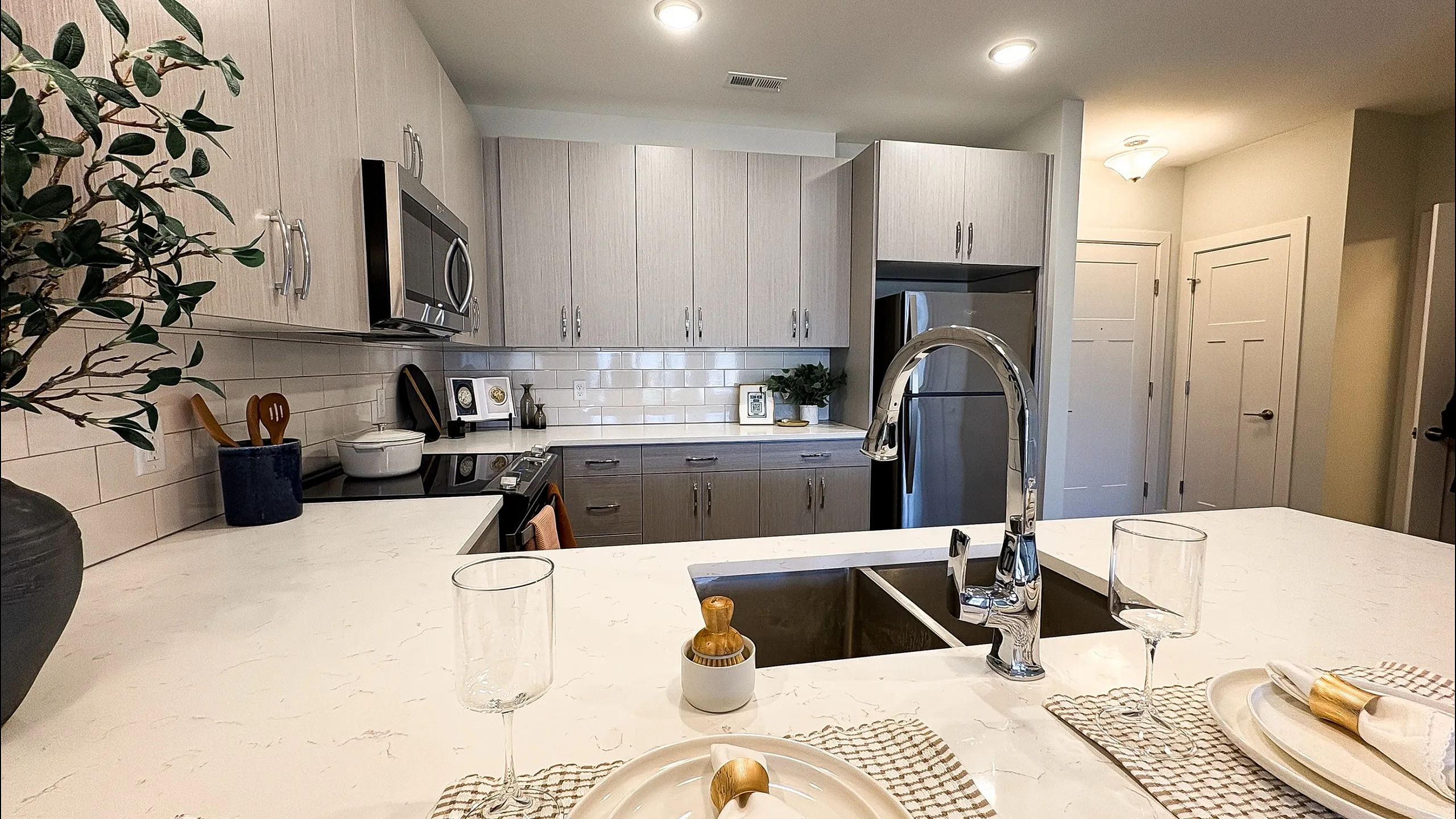 Modern kitchen with sleek stainless steel appliances, elegant cabinetry, and a wide marble island set for dining.