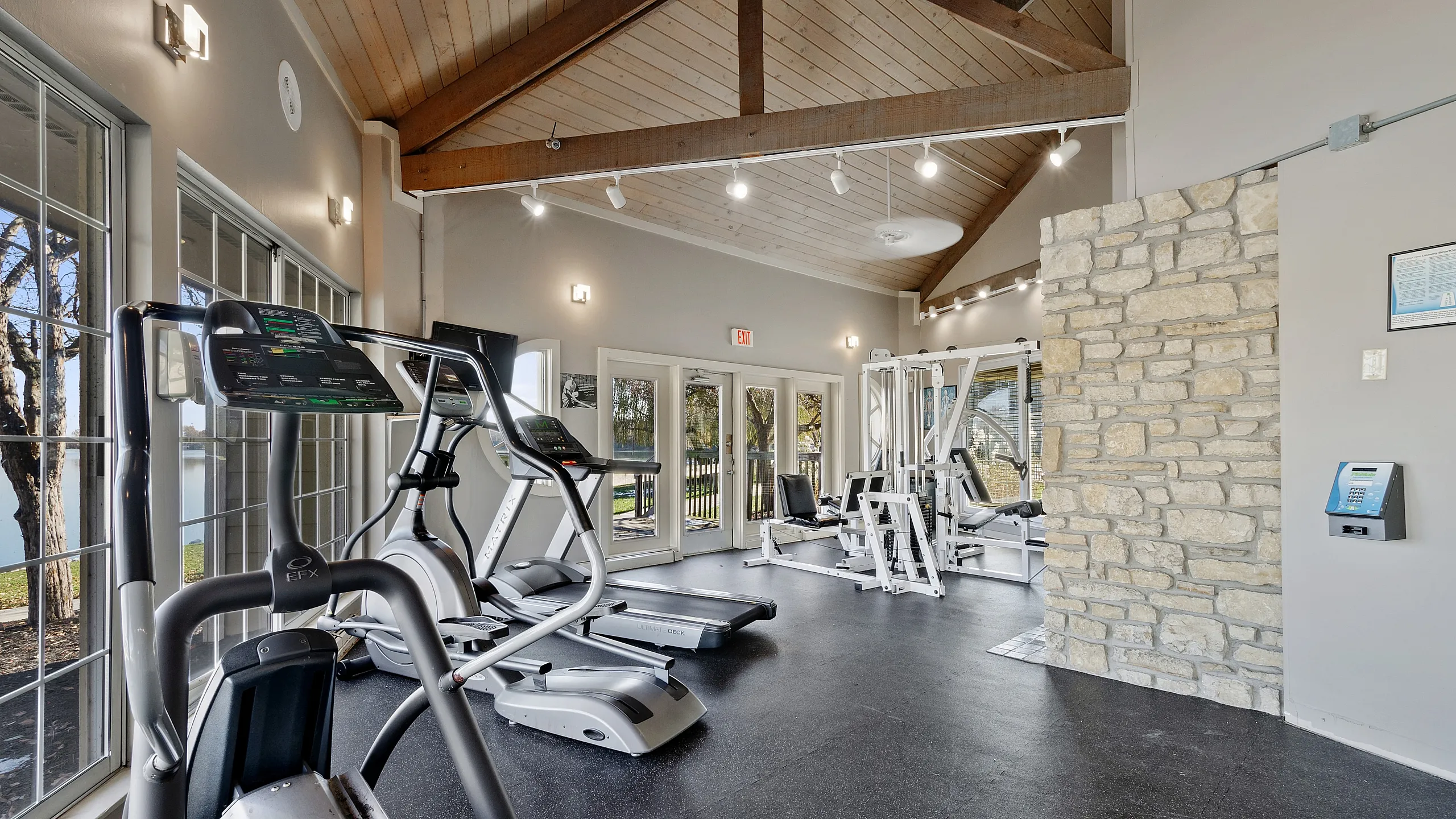 Bright and modern gym with state-of-the-art exercise equipment and expansive windows offering a serene view.