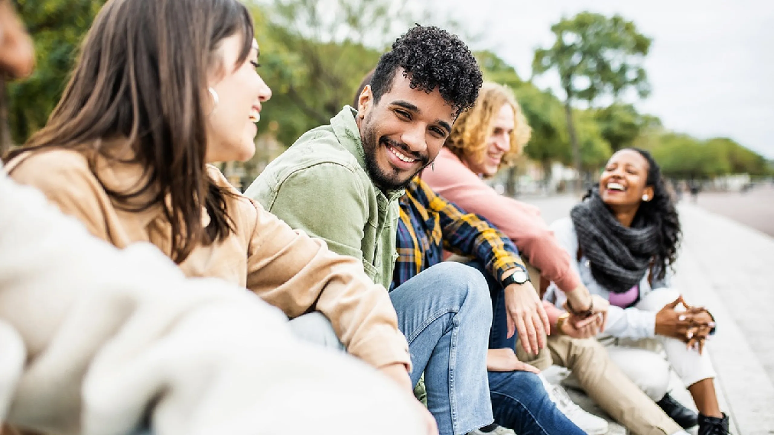 Vibrant group of friends enjoying a joyful day outside, full of smiles and laughter.