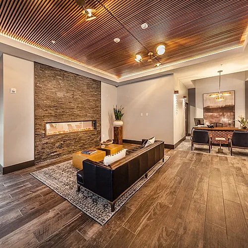Luxurious living room with elegant wooden ceiling, sleek stone fireplace, and modern furnishings.