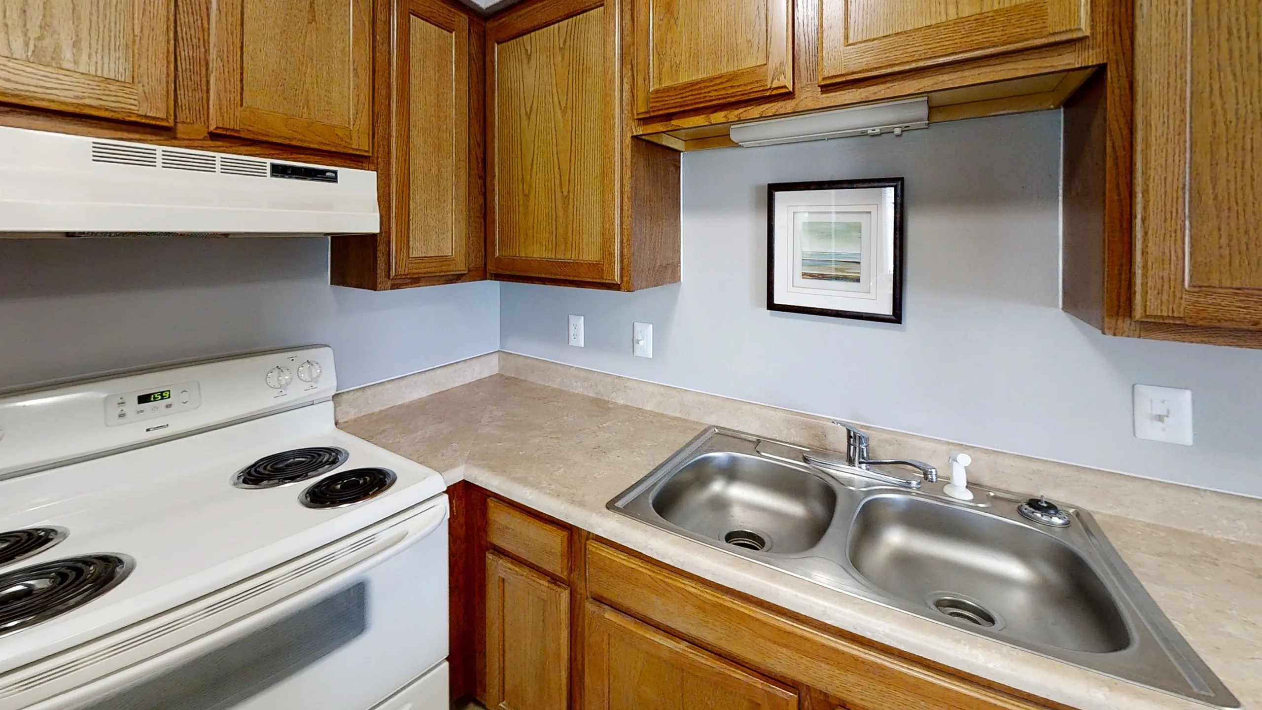 Landmark Apartments Charming kitchen featuring warm wooden cabinets, sleek countertops, and modern appliances.