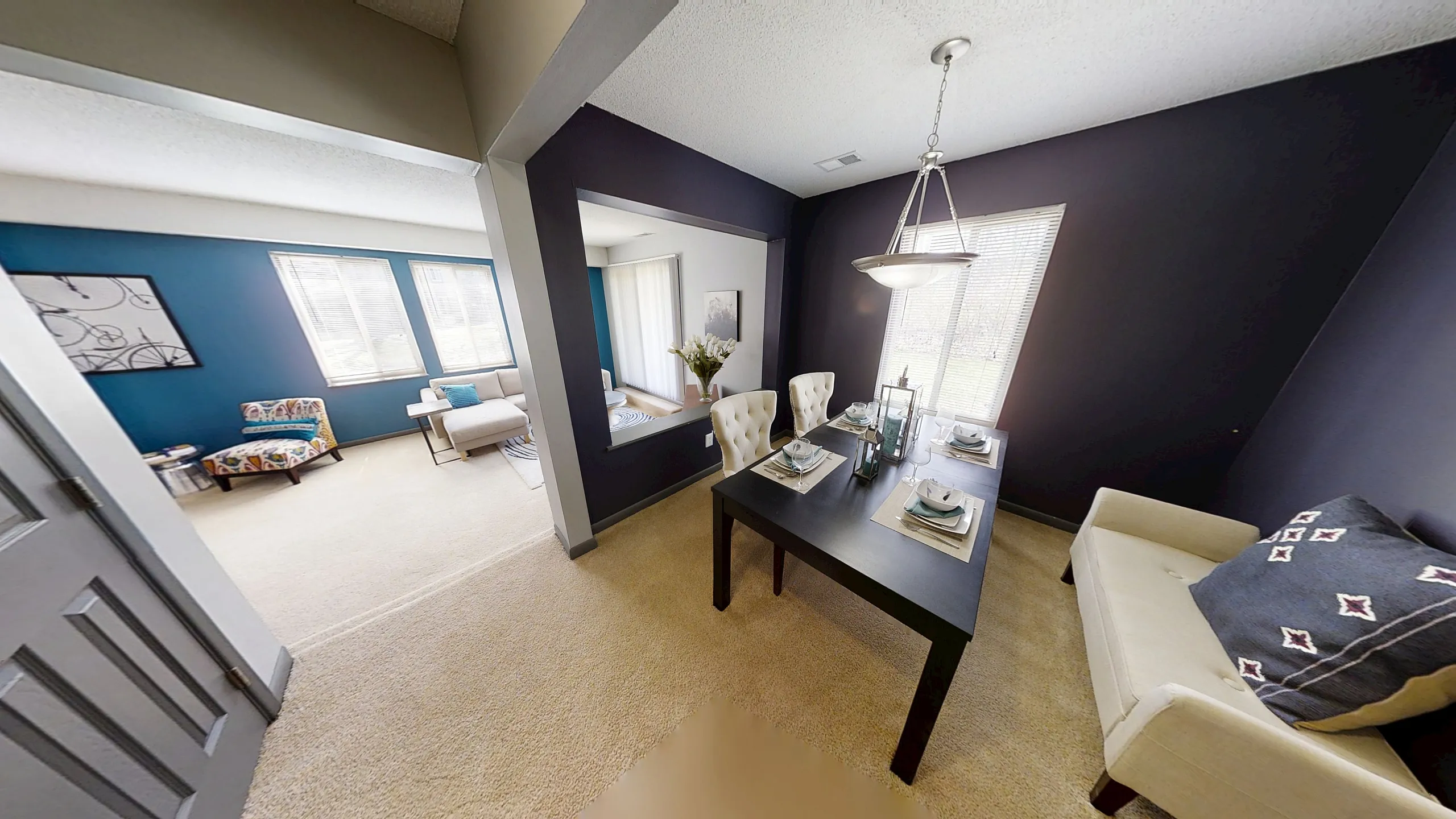 Inviting open-concept living space with elegant dining area and cozy, sunlit sitting room featuring modern decor.
