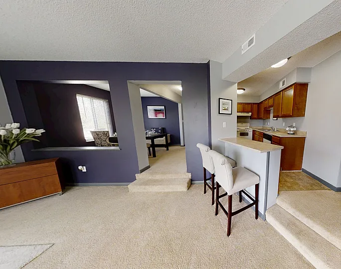 Inviting open-concept living area with modern kitchen, cozy bar seating, and elegant decor.