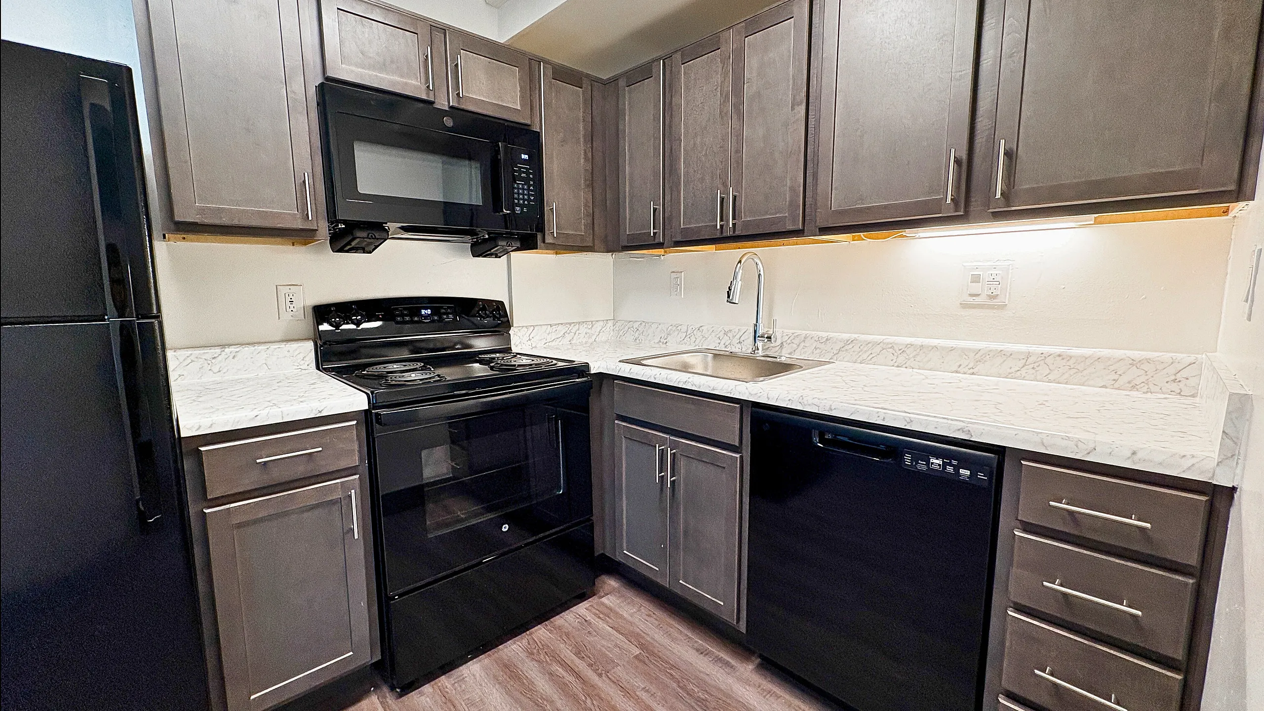 Turtle Creek Contemporary kitchen with sleek dark cabinetry, modern appliances, and elegant marble countertops.