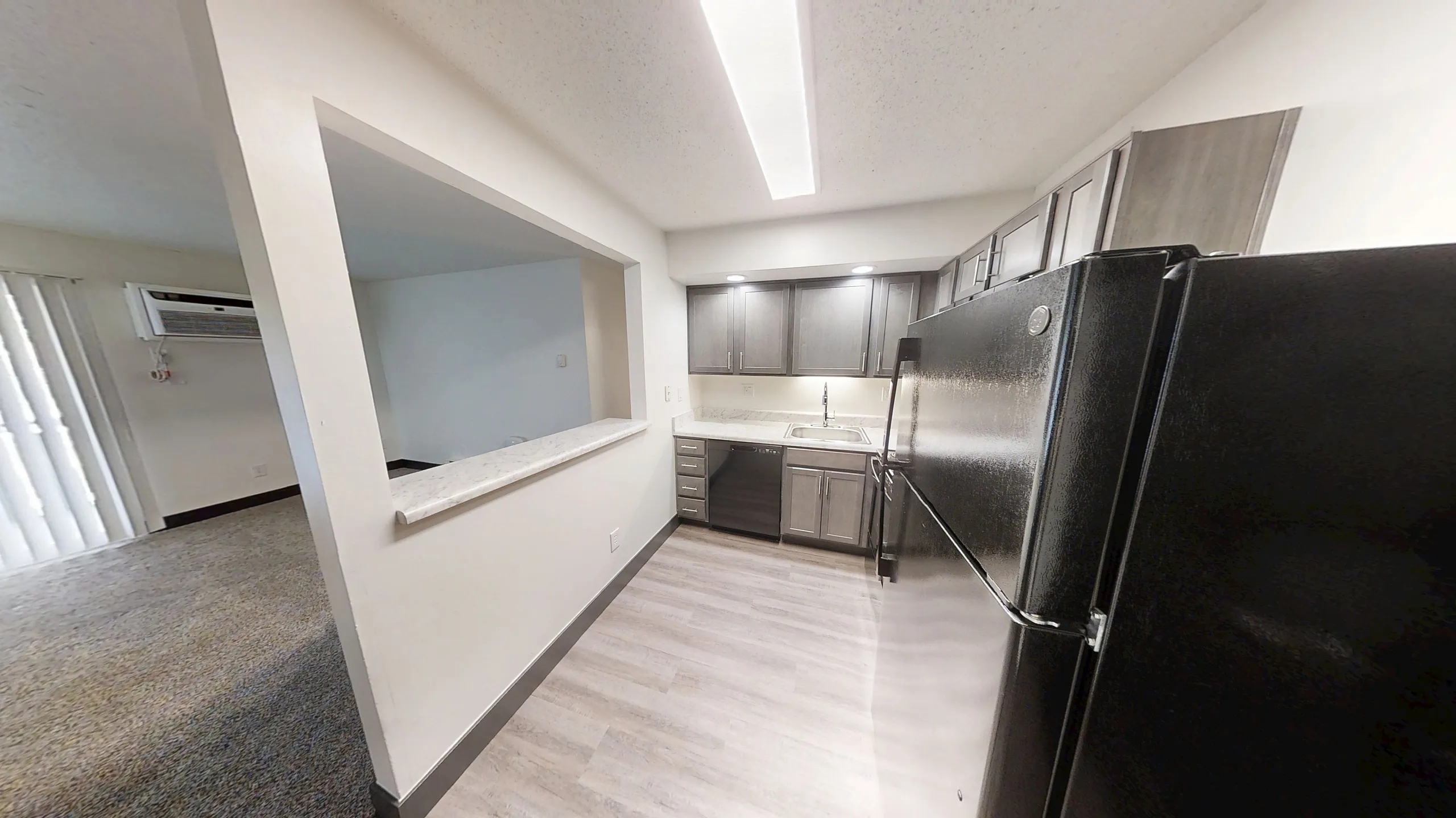 Modern kitchen with sleek cabinetry, stainless steel appliances, and bright overhead lighting, offering a seamless blend of style and functionality.
