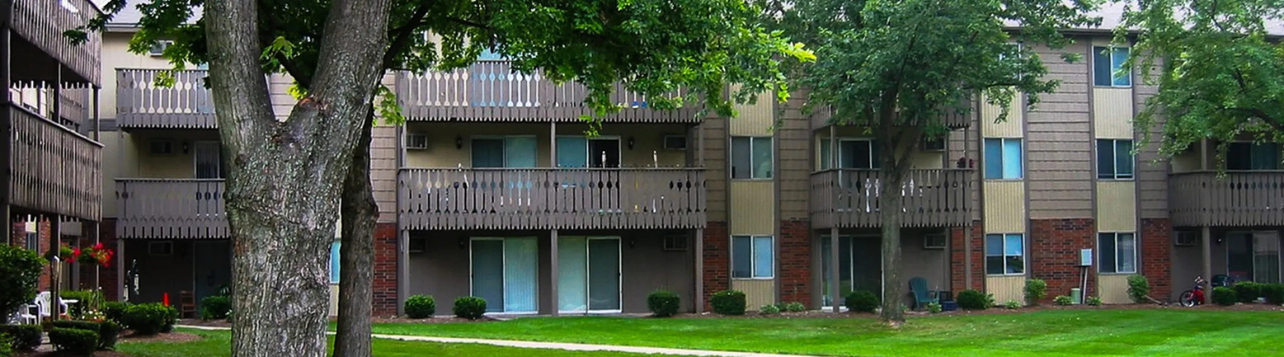 Charming Turtle Creek apartment building with lush greenery, spacious balconies, and serene surroundings.