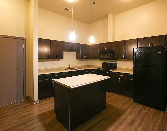 Modern kitchen with elegant dark wood cabinetry, ambient lighting, and a central island for versatile use.