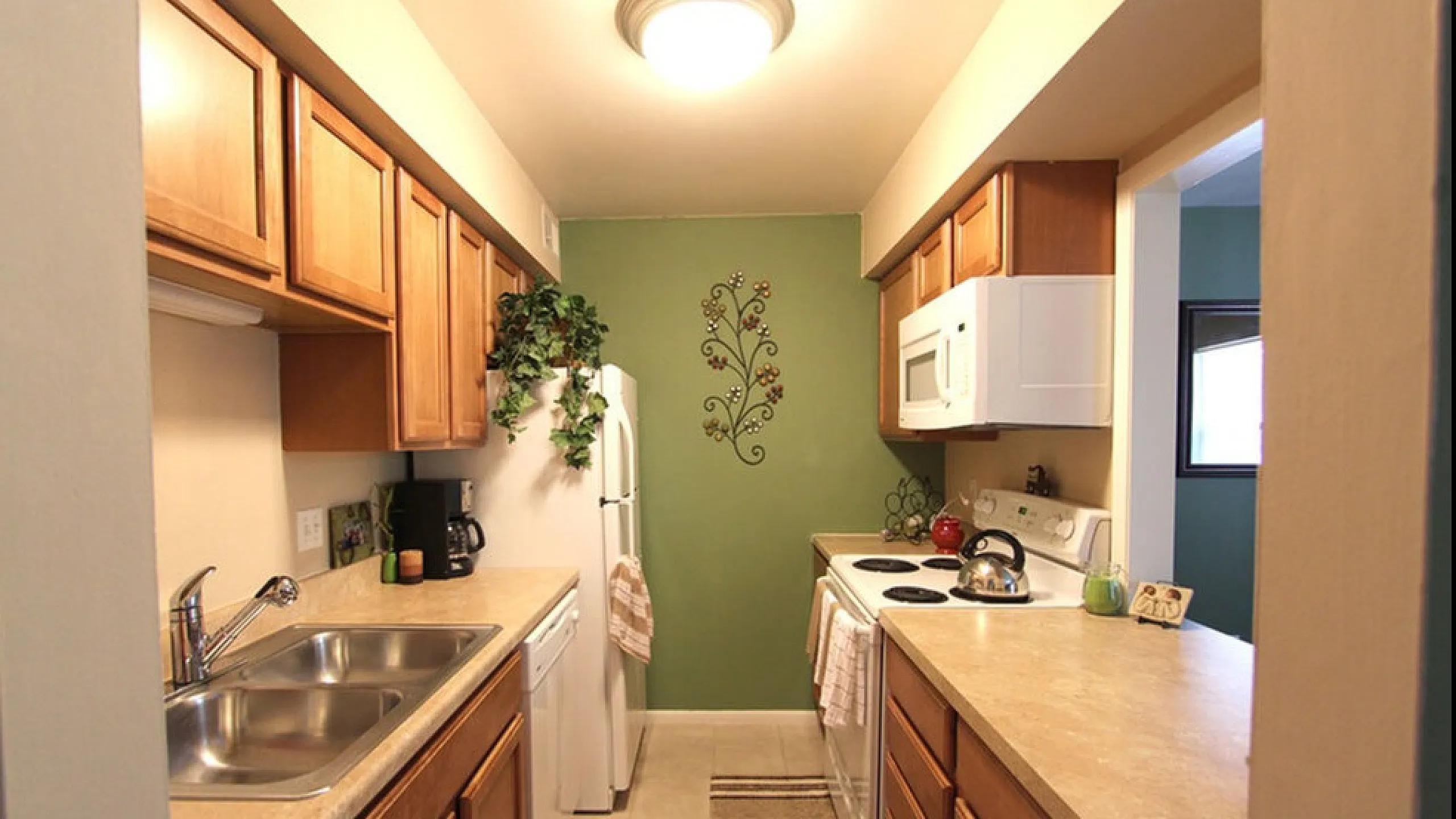 Northview Apartments: Cozy kitchen with elegant wooden cabinets, modern appliances, and decorative wall art, perfect for culinary exploration.