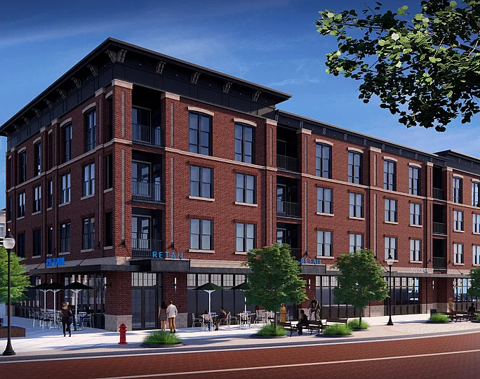 Charming urban apartment building with a classic brick facade, featuring ground-floor retail spaces and tree-lined sidewalks for a vibrant city living experience.