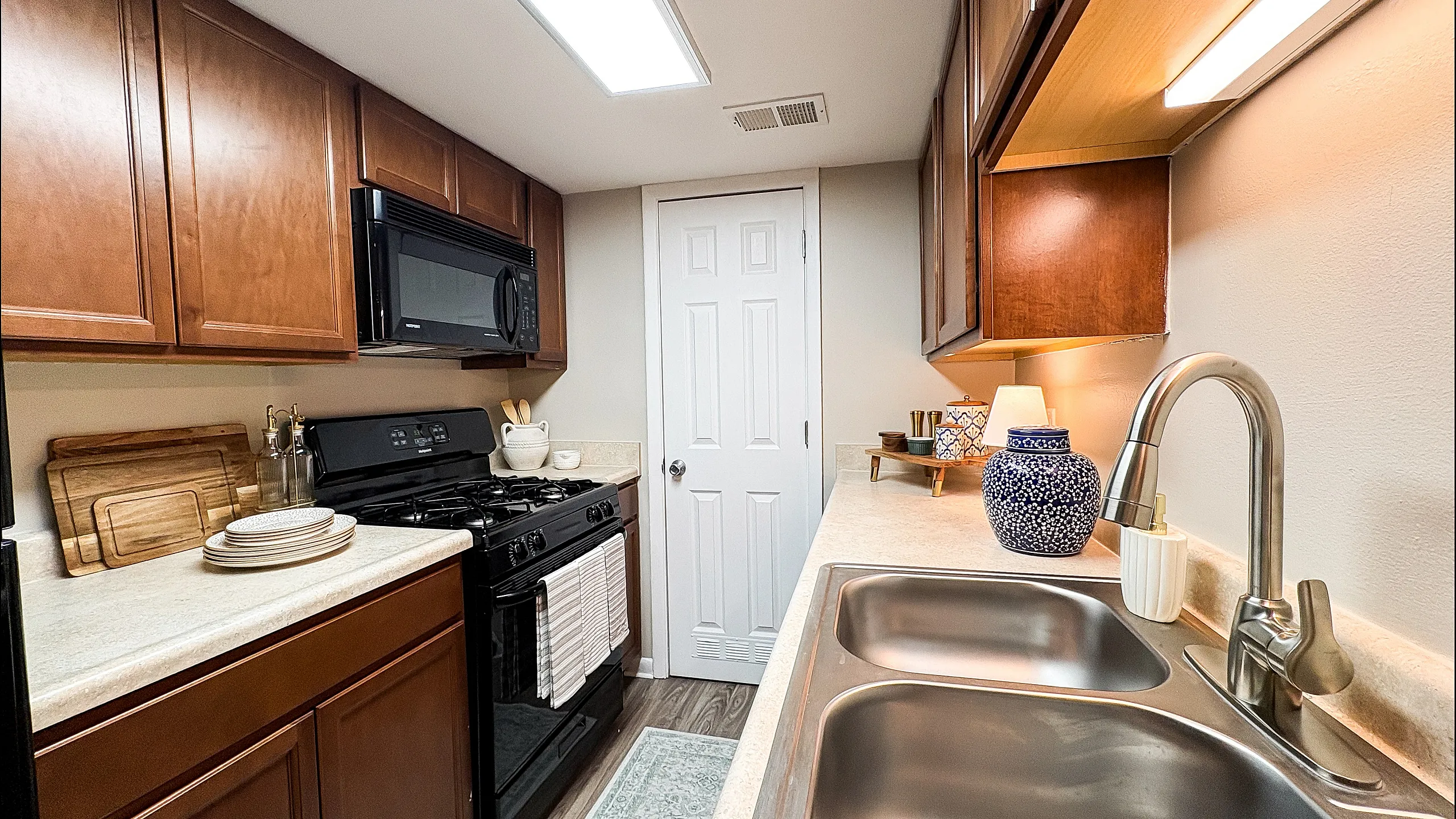 Charming kitchen with sleek countertops, modern appliances, and elegant wooden cabinetry creating a warm and inviting atmosphere.