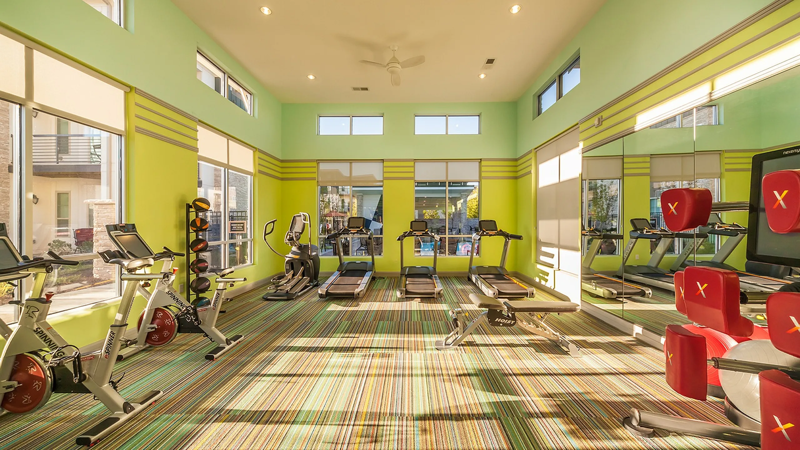 Bright, modern fitness center equipped with state-of-the-art exercise machines and vibrant interiors, perfect for a dynamic workout experience.