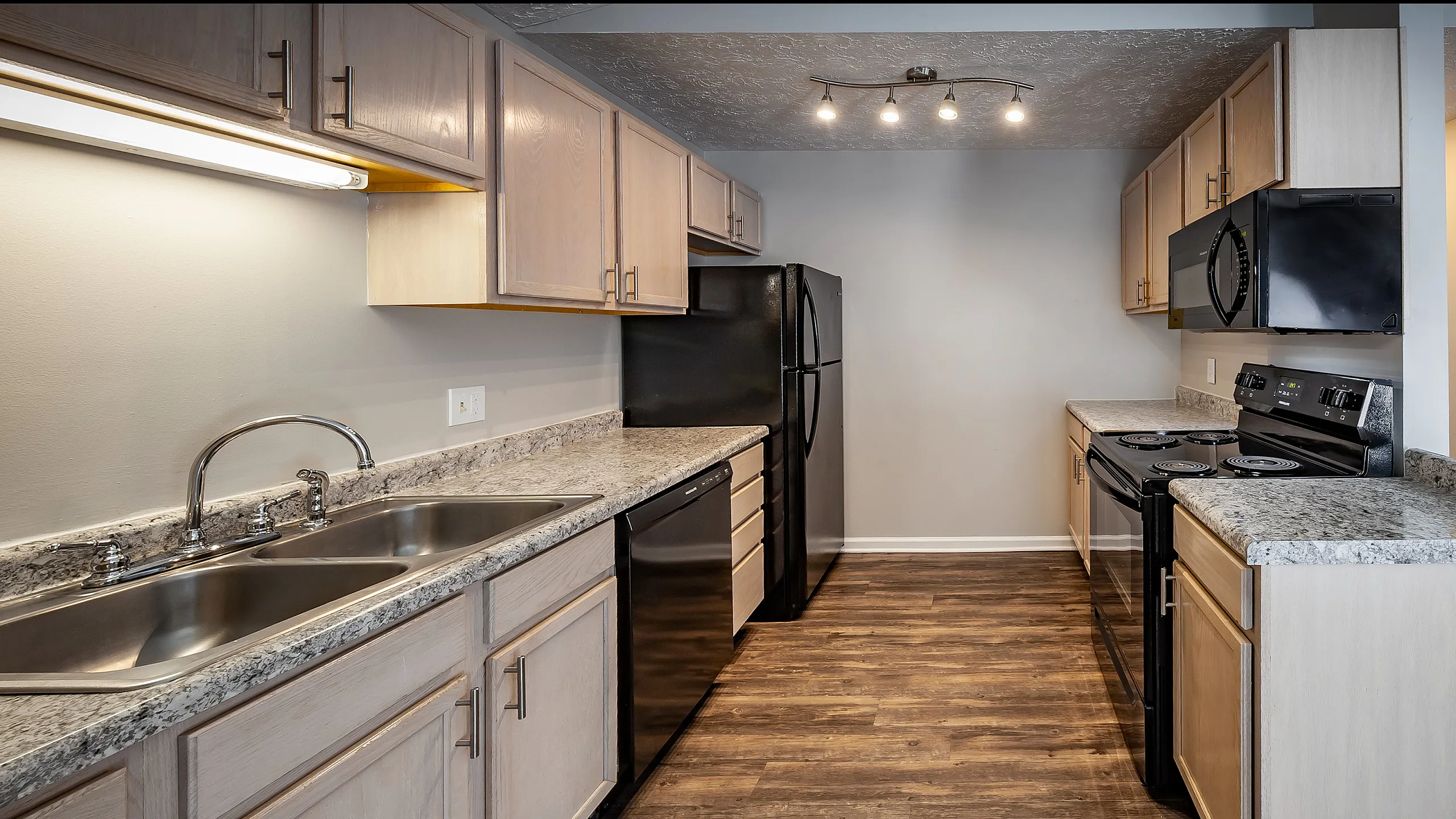 Modern kitchen featuring sleek granite countertops, elegant wood cabinetry, and stainless steel appliances with stylish lighting.