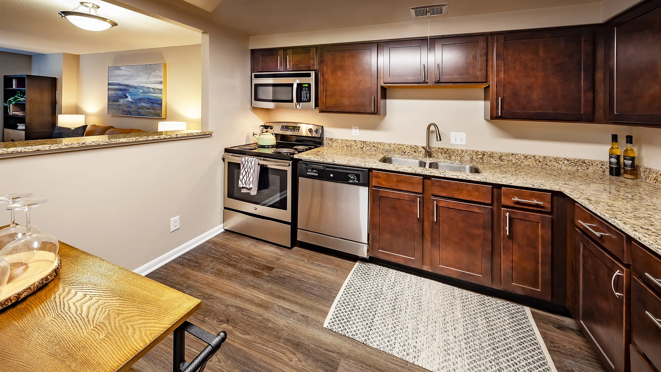 Elegant kitchen with granite countertops, stainless steel appliances, and rich wooden cabinetry, offering a blend of functionality and modern style.