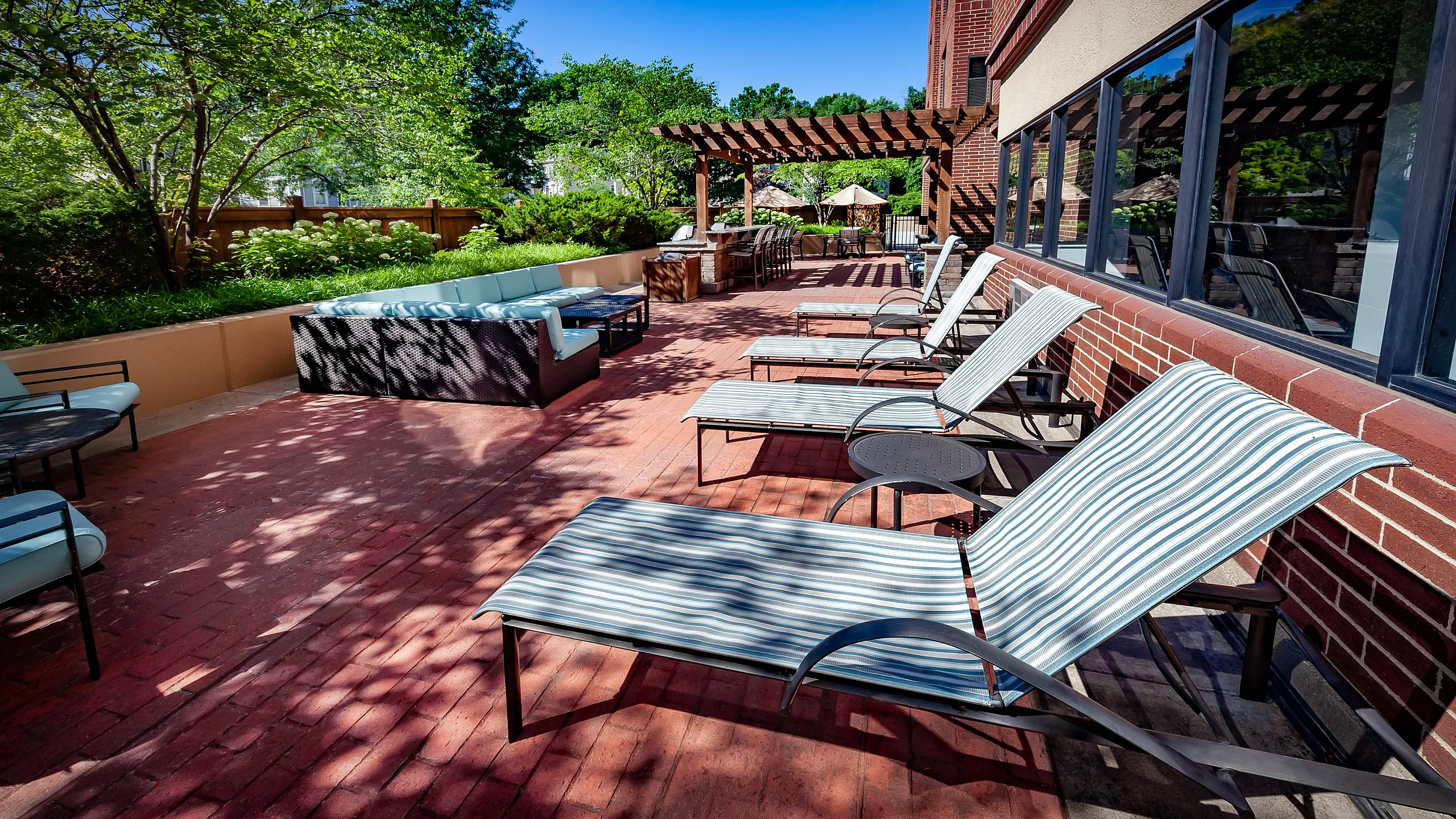 Charming outdoor patio with stylish lounge chairs and shaded seating area, perfect for relaxation and entertaining.
