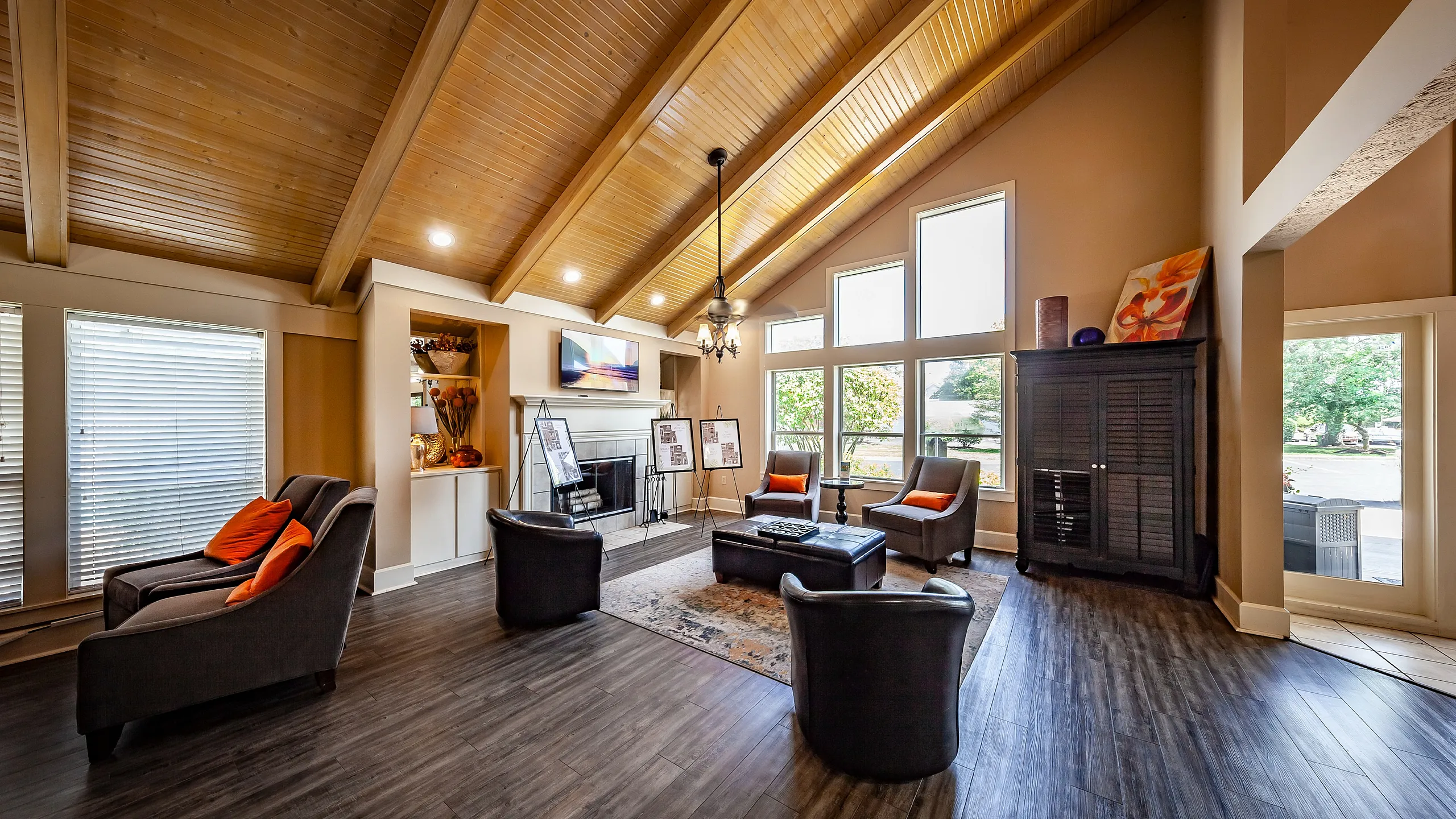 Spacious and elegant clubhouse with vaulted wood ceiling, large windows, and comfortable seating. Natural light enhances the modern decor, creating a warm and inviting atmosphere.