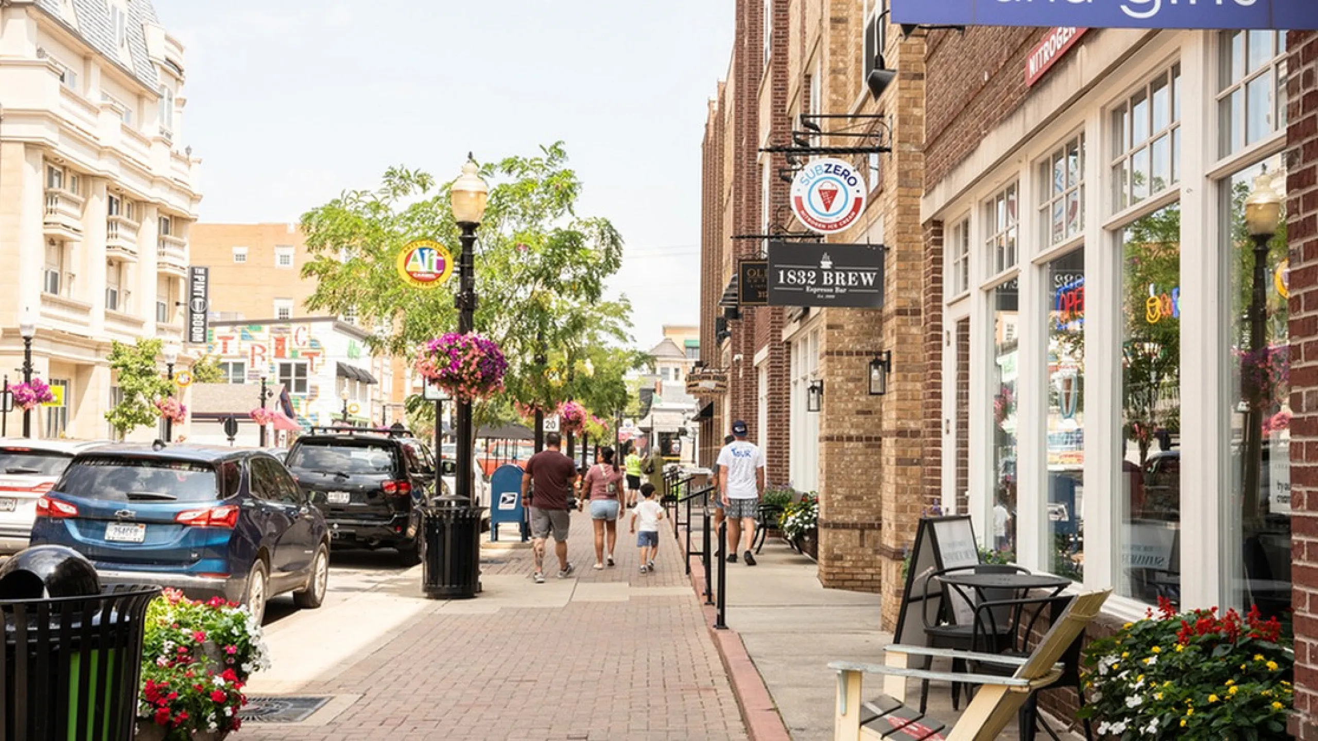 Main Street on the Monon Charming streetscape with boutique shops, lively greenery, and vibrant street life creating a welcoming atmosphere.