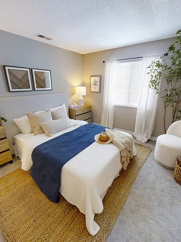Inviting bedroom with cozy neutral tones, elegant decor, and a bright window view.