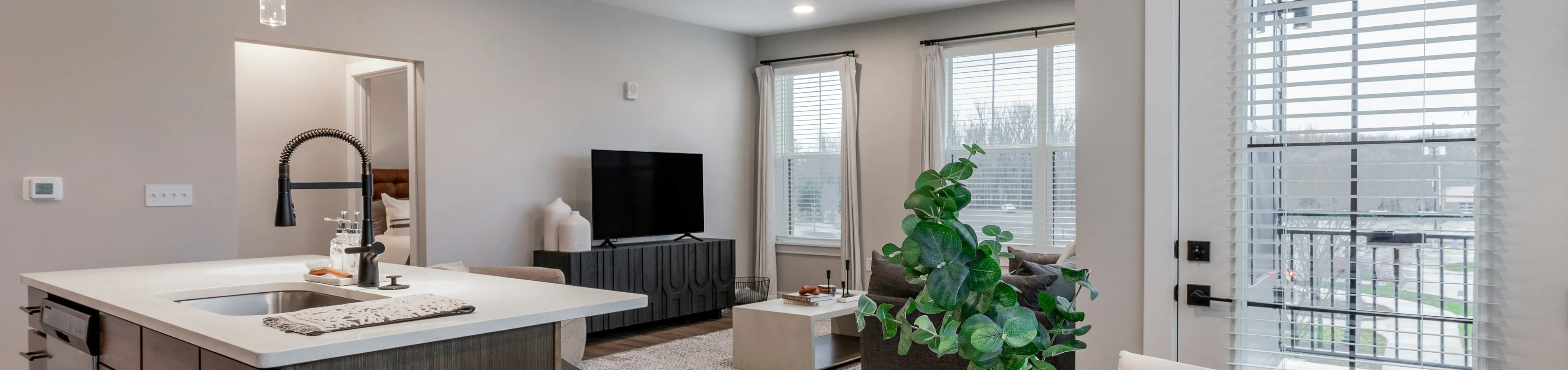 Chic open-concept living area showcasing a modern kitchen island, elegant dining setup, and cozy living room with abundant natural light.