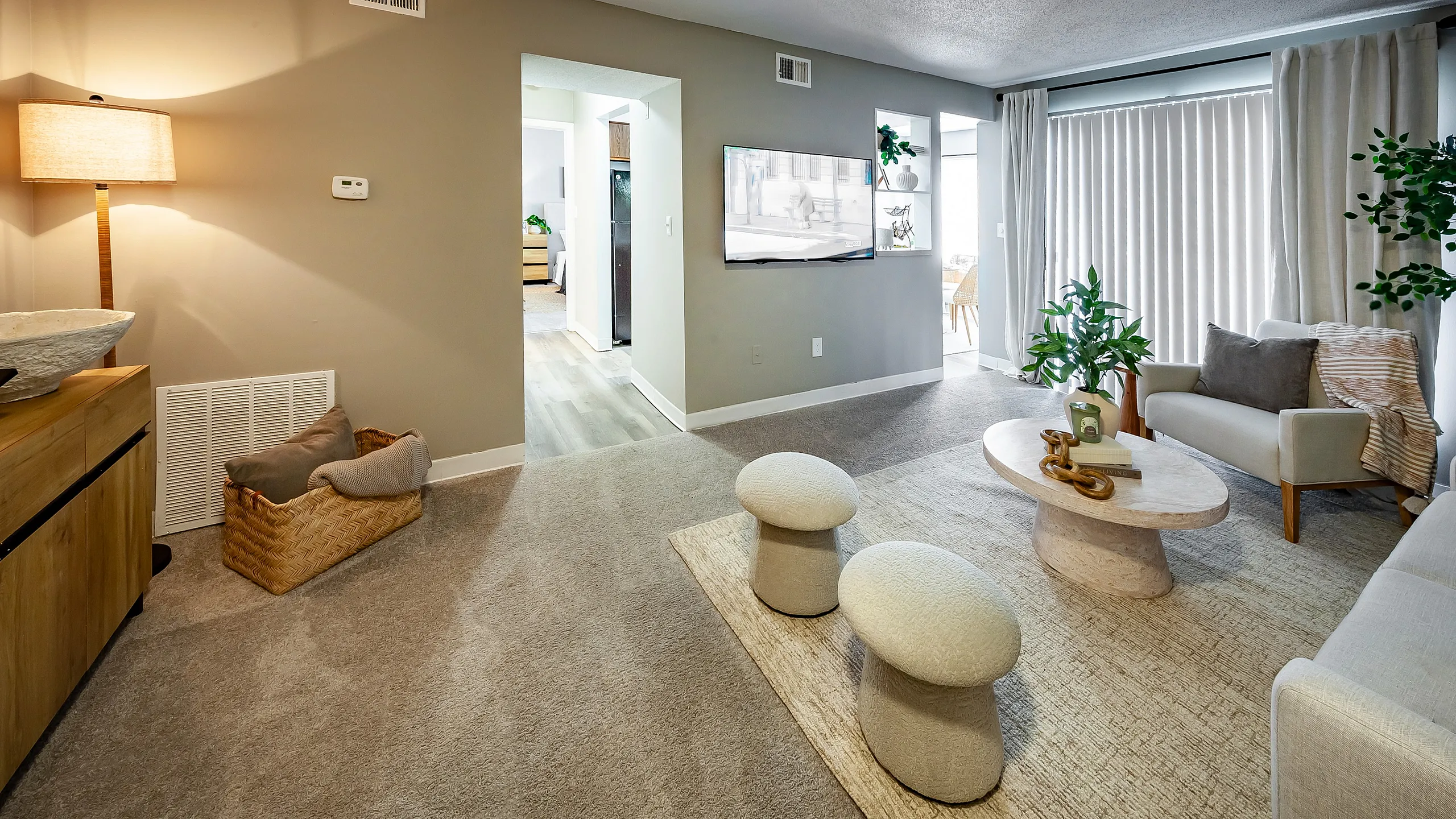 Inviting living room with cozy seating, stylish decor, and ample natural light pouring through large windows.