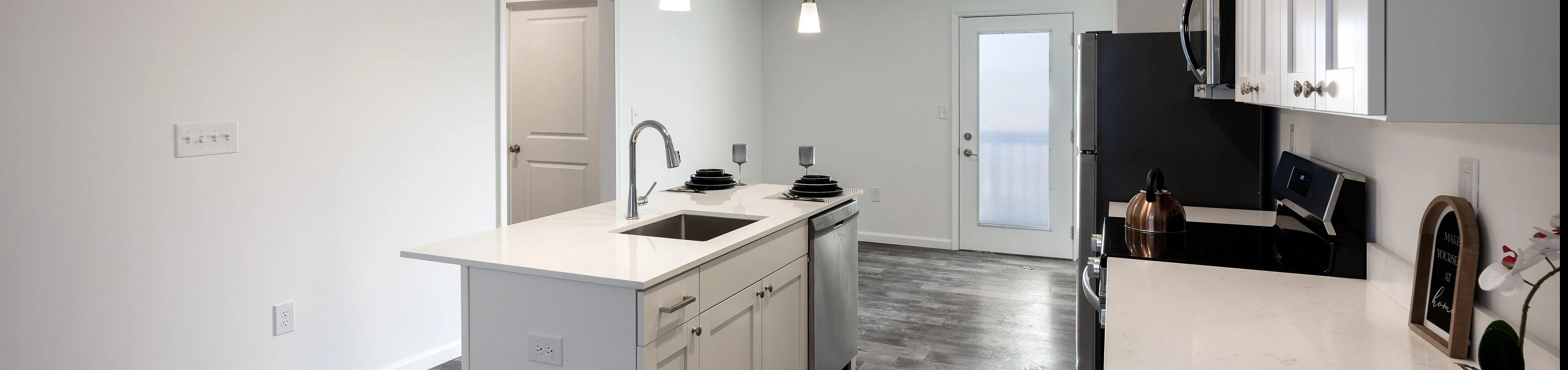 Modern kitchen with sleek white cabinetry, a spacious island, and elegant pendant lighting, perfect for entertaining.