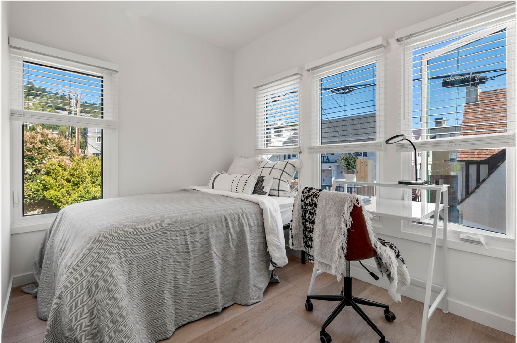 Bright bedroom with modern decor and large windows.