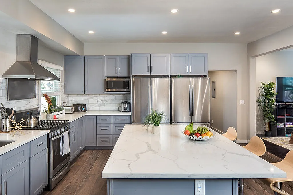 Modern kitchen with sleek gray cabinets, stainless steel appliances, and a large marble island perfect for entertaining.