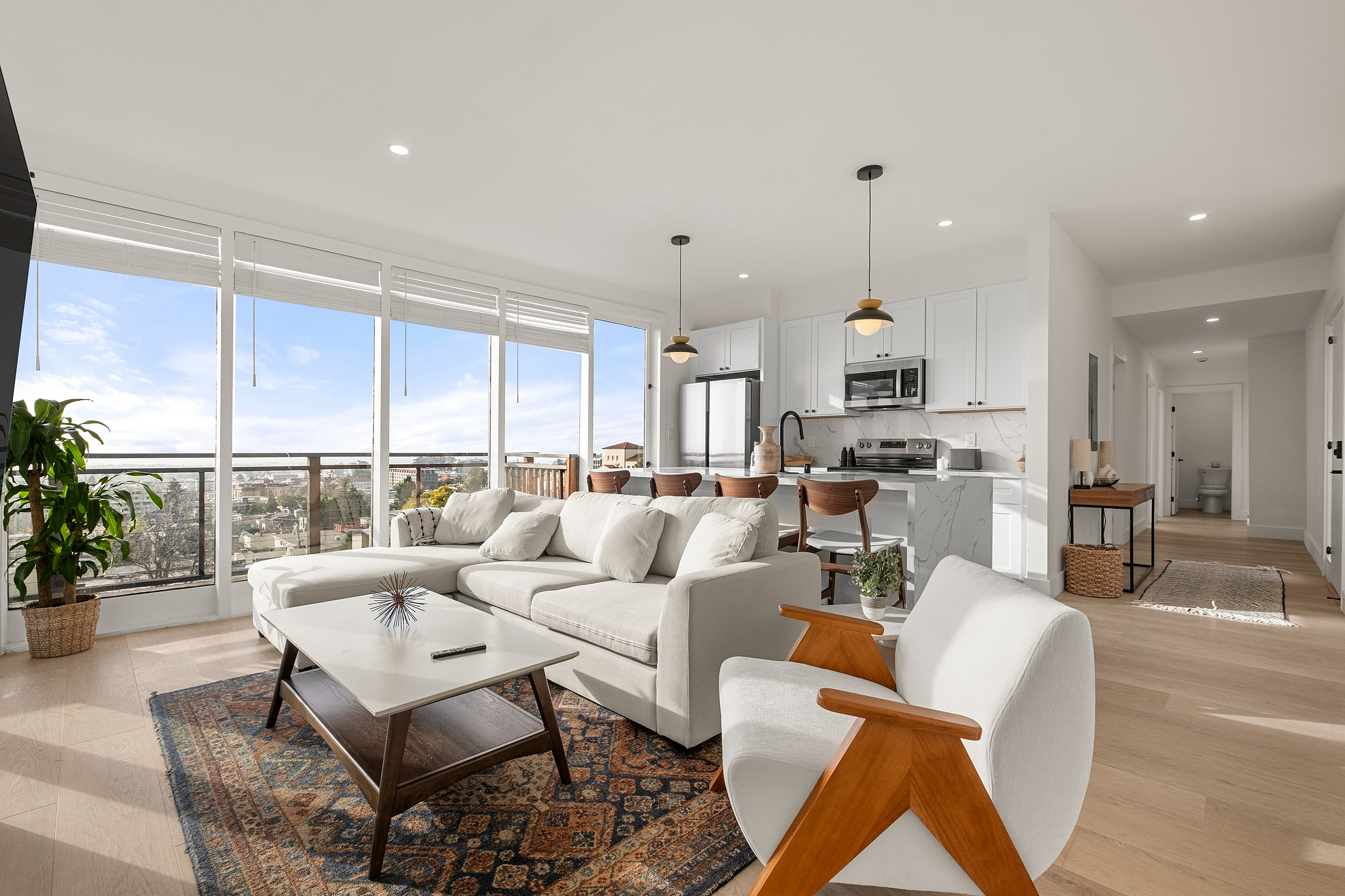 Modern open-concept living space with elegant decor, panoramic city views, and bright natural lighting.