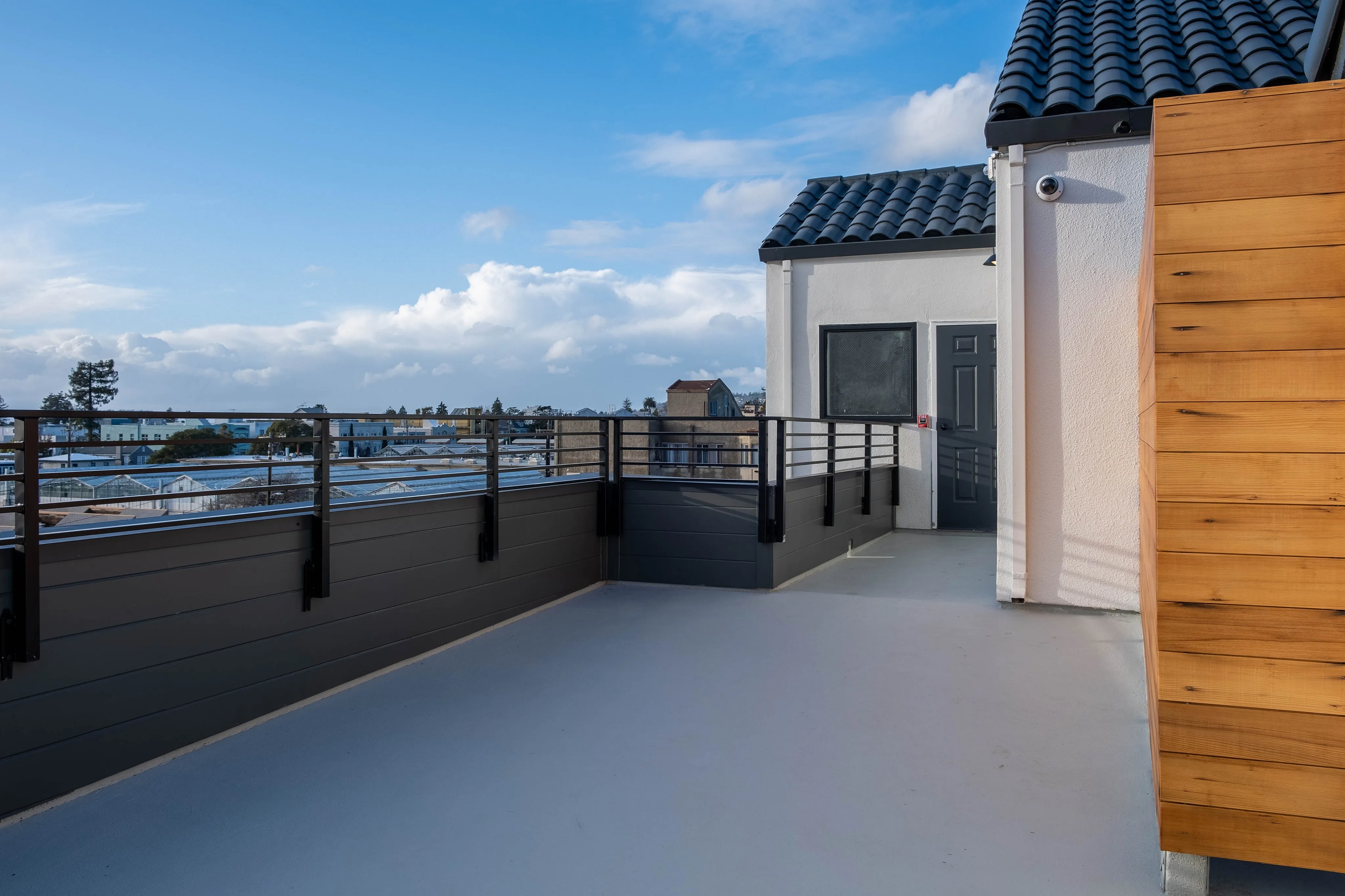 Spacious rooftop terrace with sleek railing and vibrant sky views, perfect for entertaining and relaxation.