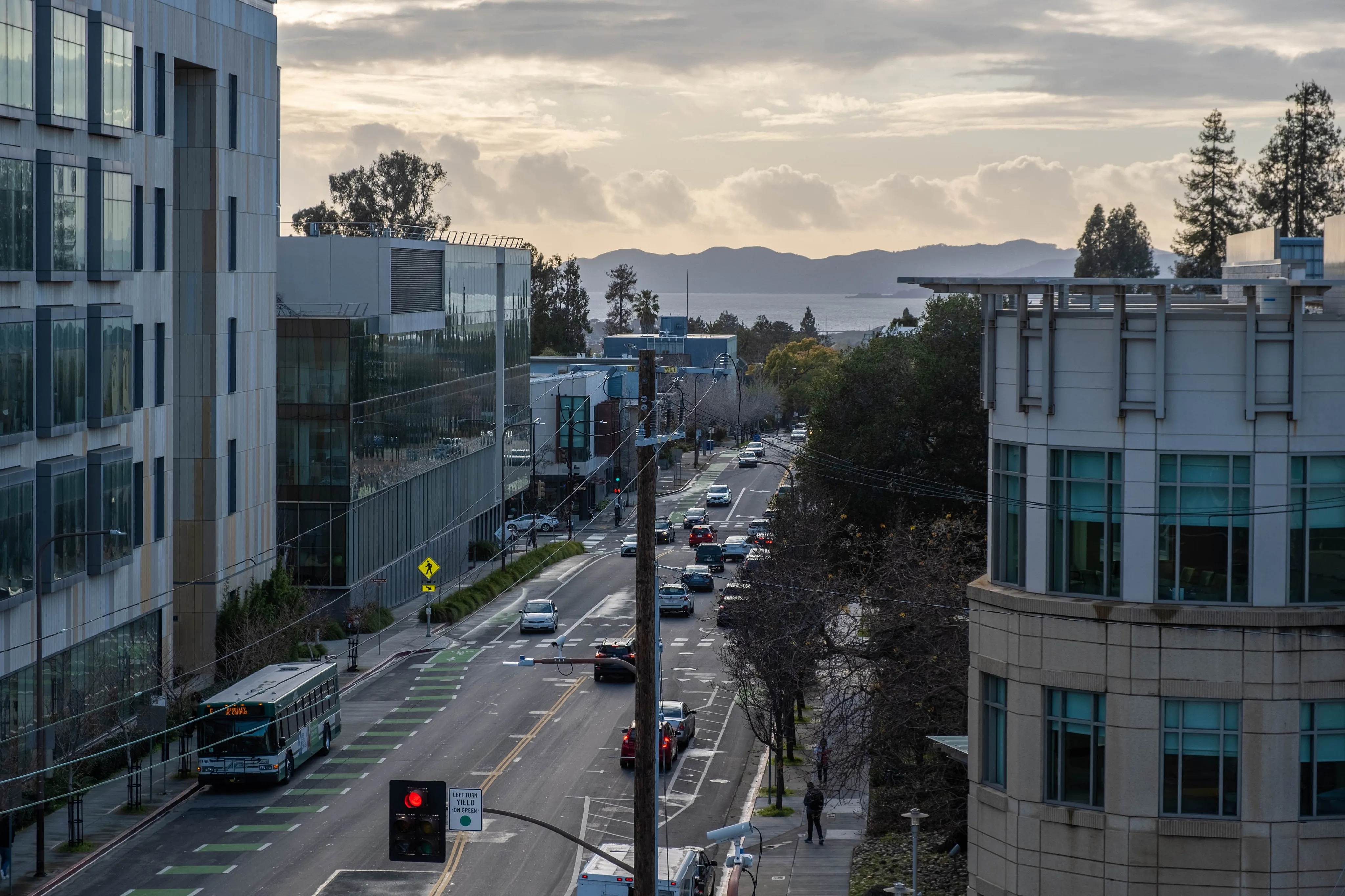 Dynamic cityscape view showcasing modern architecture, bustling urban street, and serene waterfront in the distance.