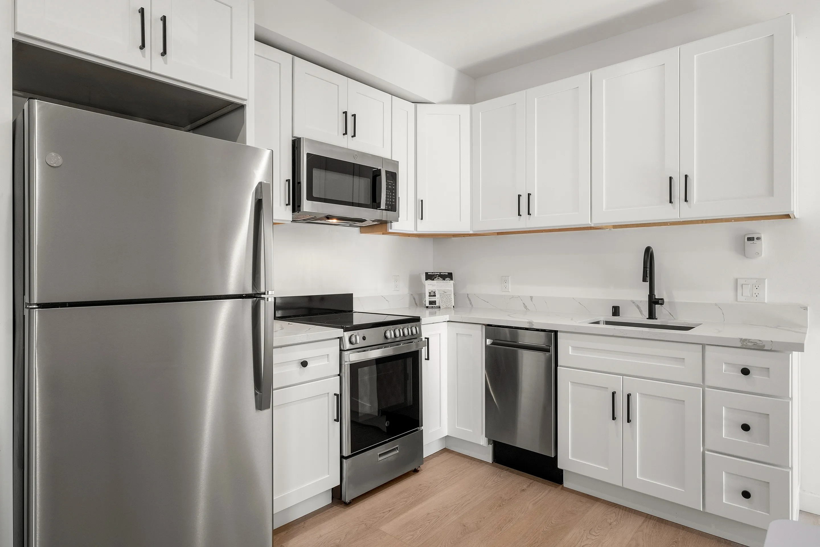 Modern kitchen with sleek stainless steel appliances, elegant white cabinetry, and chic marble countertops.