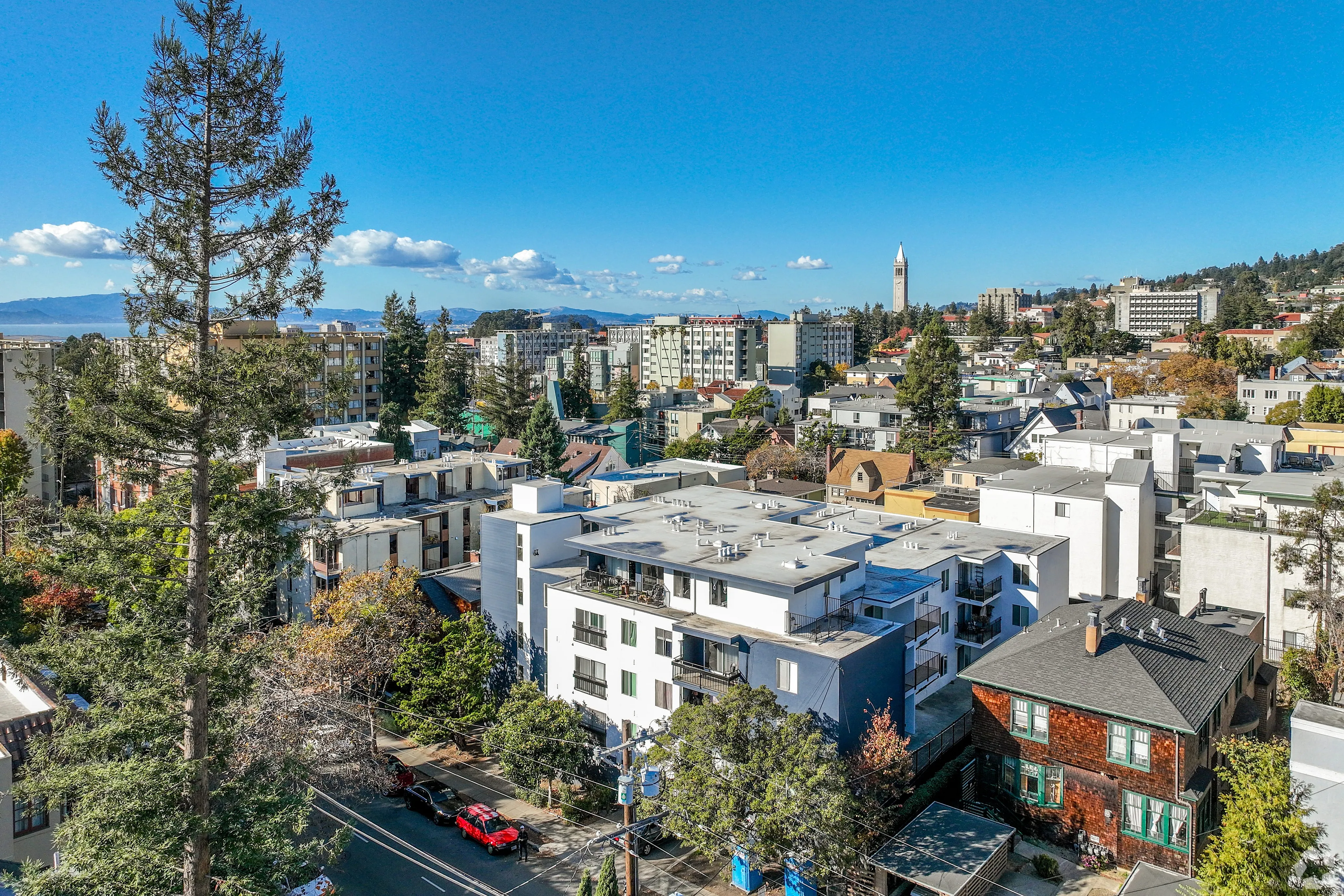 Vibrant urban landscape with modern apartment buildings and scenic views of the city skyline under a clear blue sky.